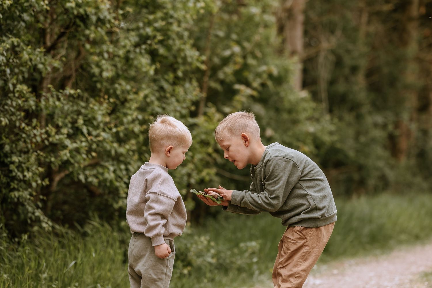 Two young children playing and interacting on a forest path.