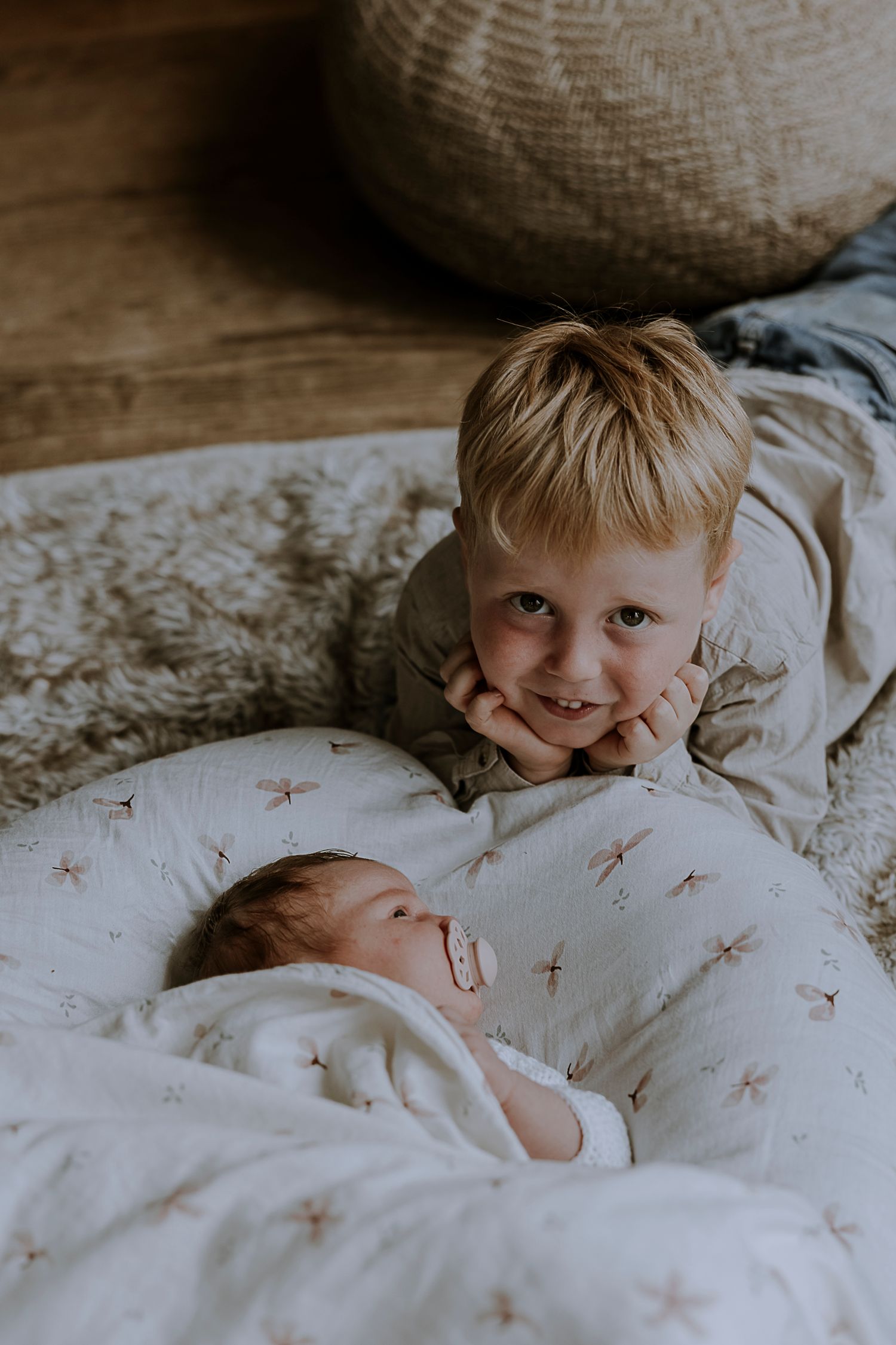 Siblings sharing an intimate moment on a star-patterned blanket.