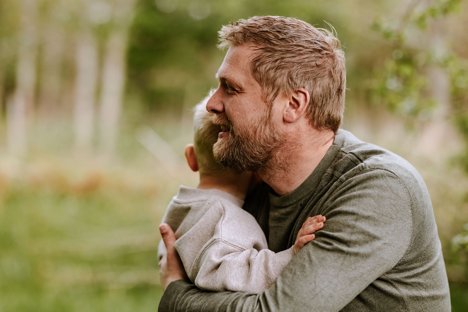 An intimate moment captured between two people embracing in a natural outdoor setting.