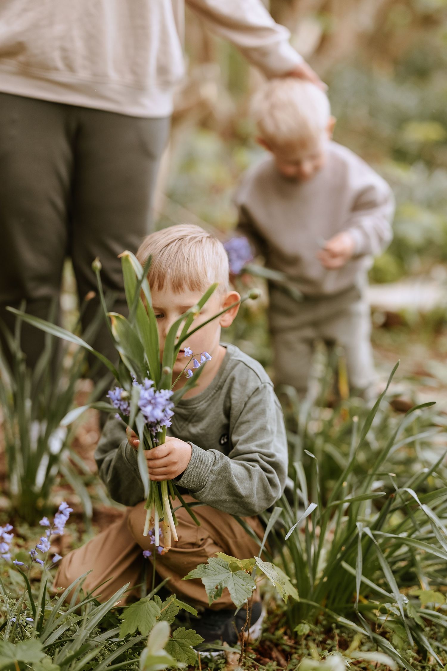 Family gathering purple flowers together in lush garden setting.