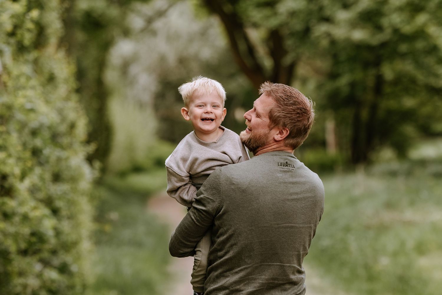 A joyful interaction between two people sharing laughter in a sunlit outdoor setting.