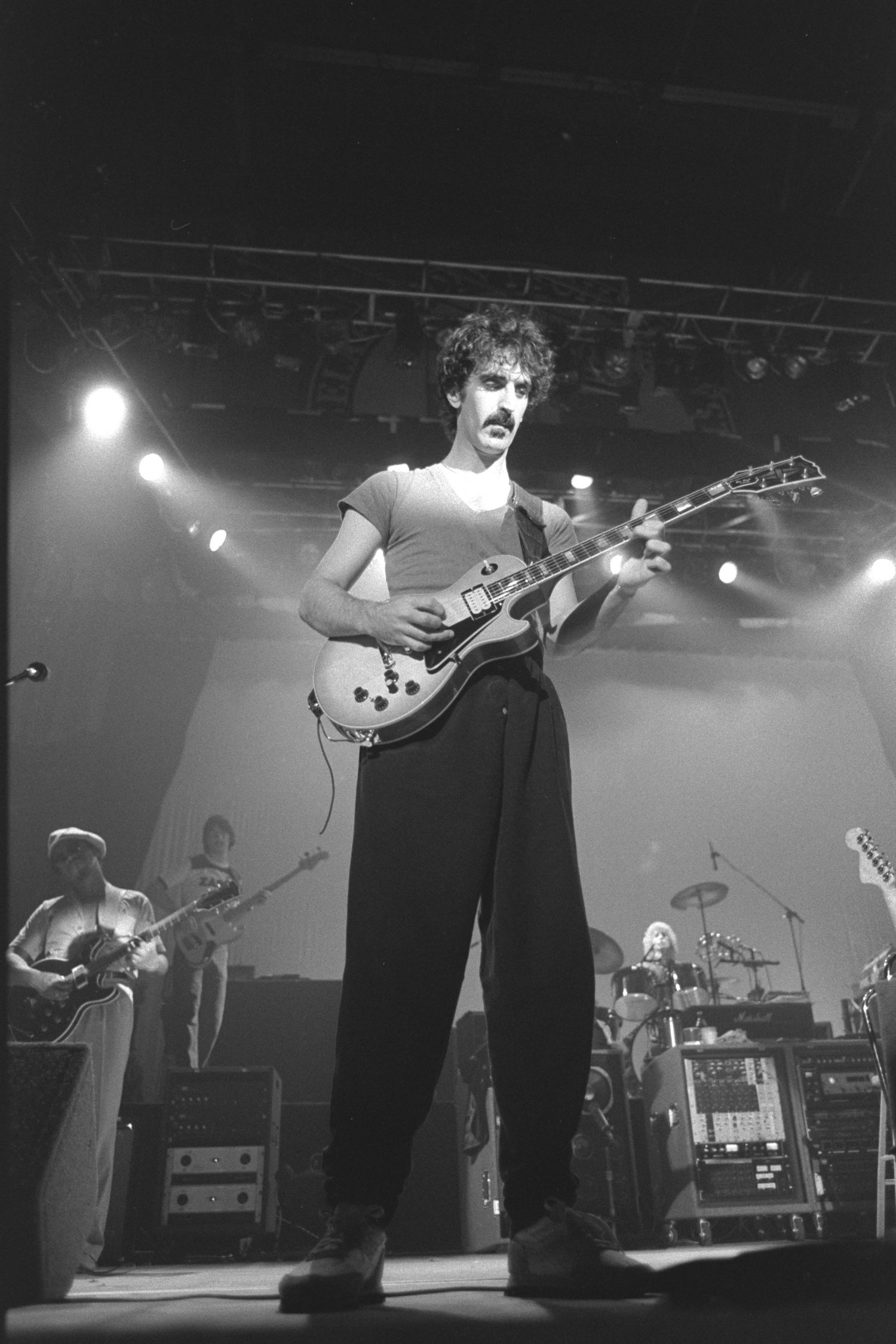 Black and white concert photos showing musicians performing on stage with guitars and instruments.