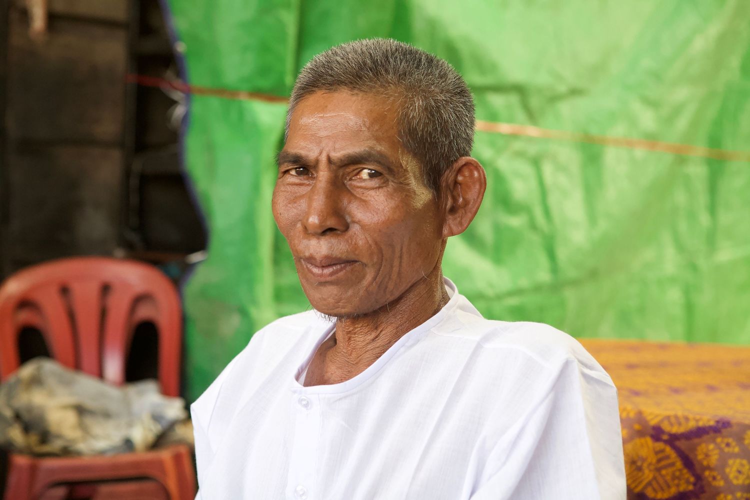 A series of portraits showing locals against a vibrant green background in Southeast Asia.