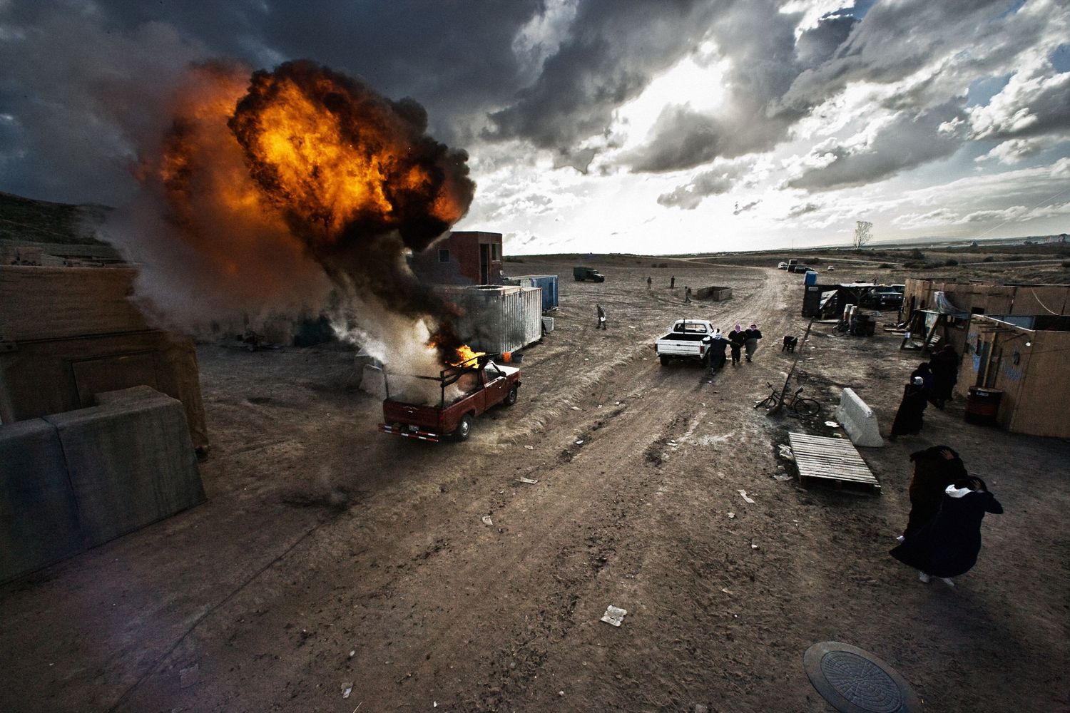 Dramatic panorama of explosions and fire in a desert combat zone.