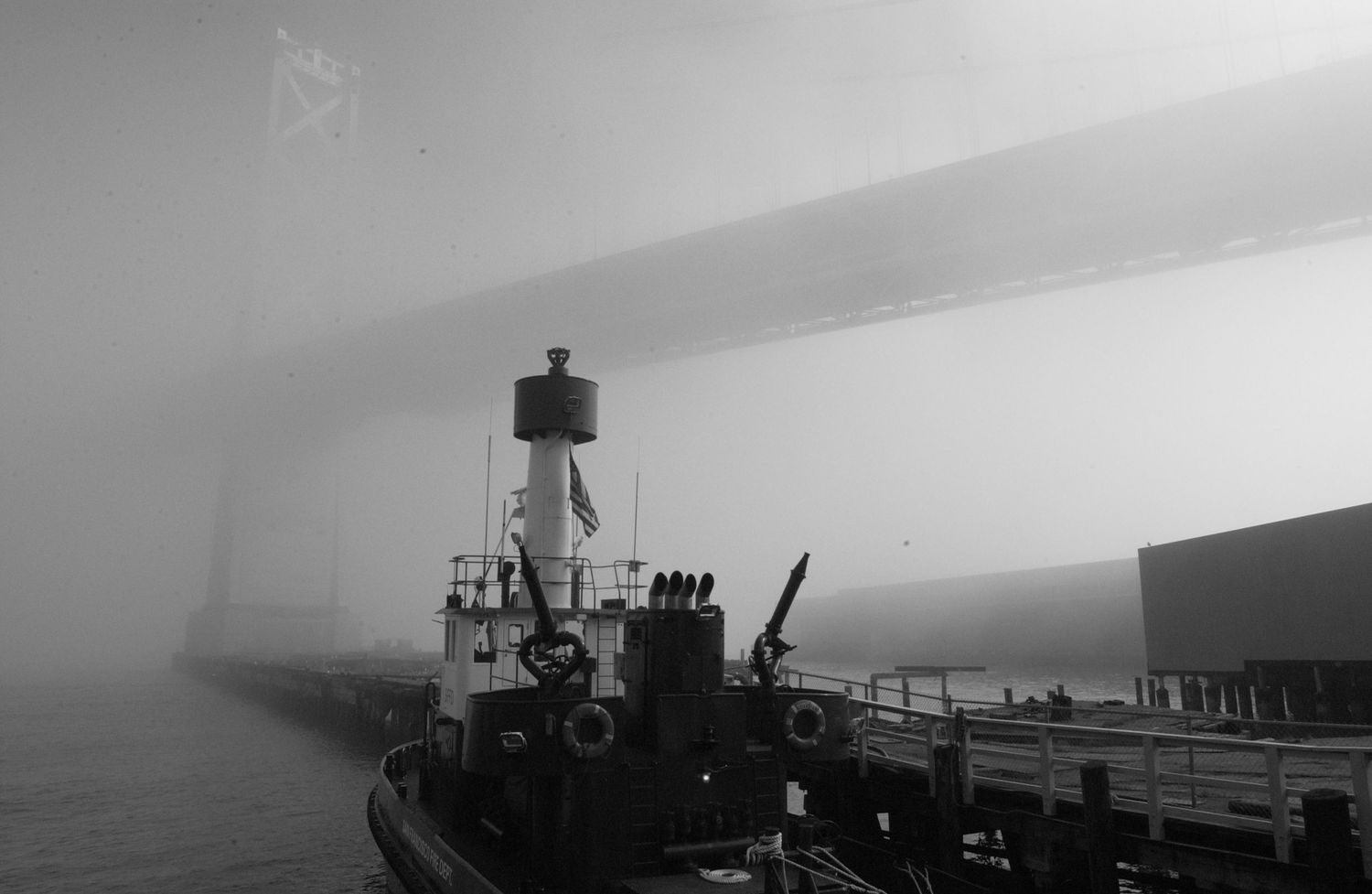 Panoramic view of ships and boats in misty harbor conditions.