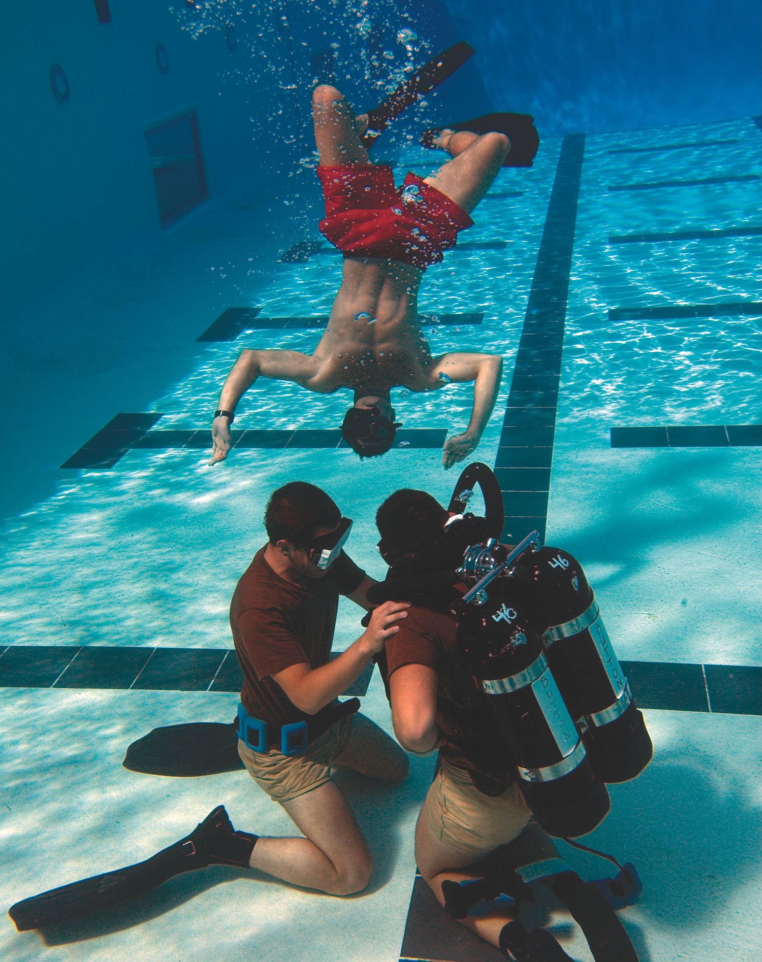 Underwater training sequence showing military divers practicing combat techniques in a pool.