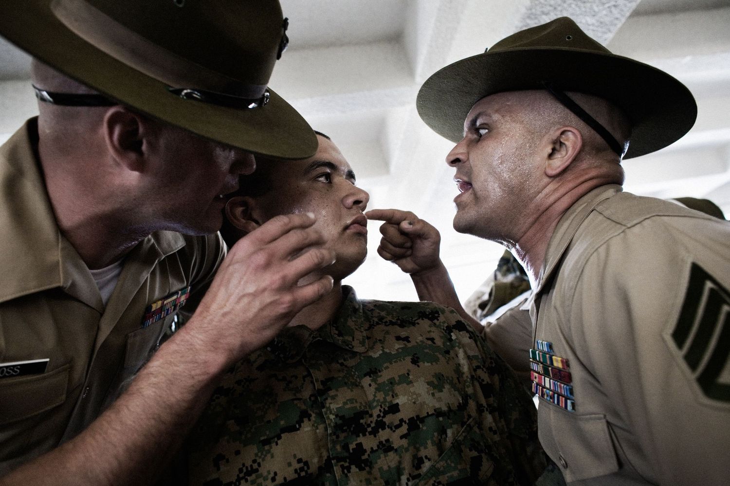 Military personnel receiving instruction during indoor training session.