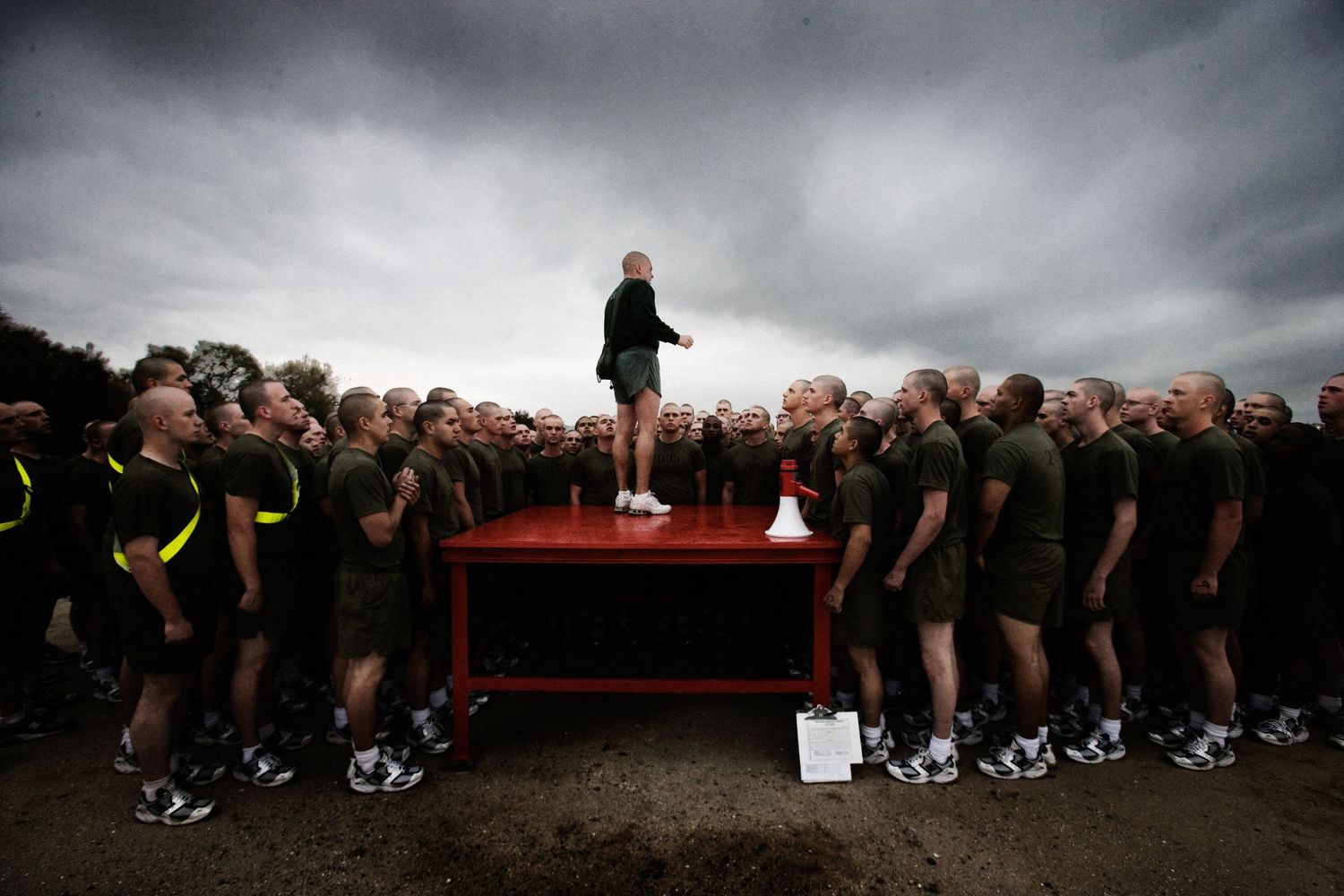 Military formation training under dramatic cloudy skies during basic training.