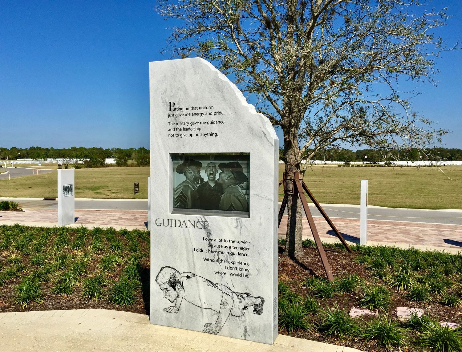 Memorial stones and markers displayed across a landscaped outdoor site.