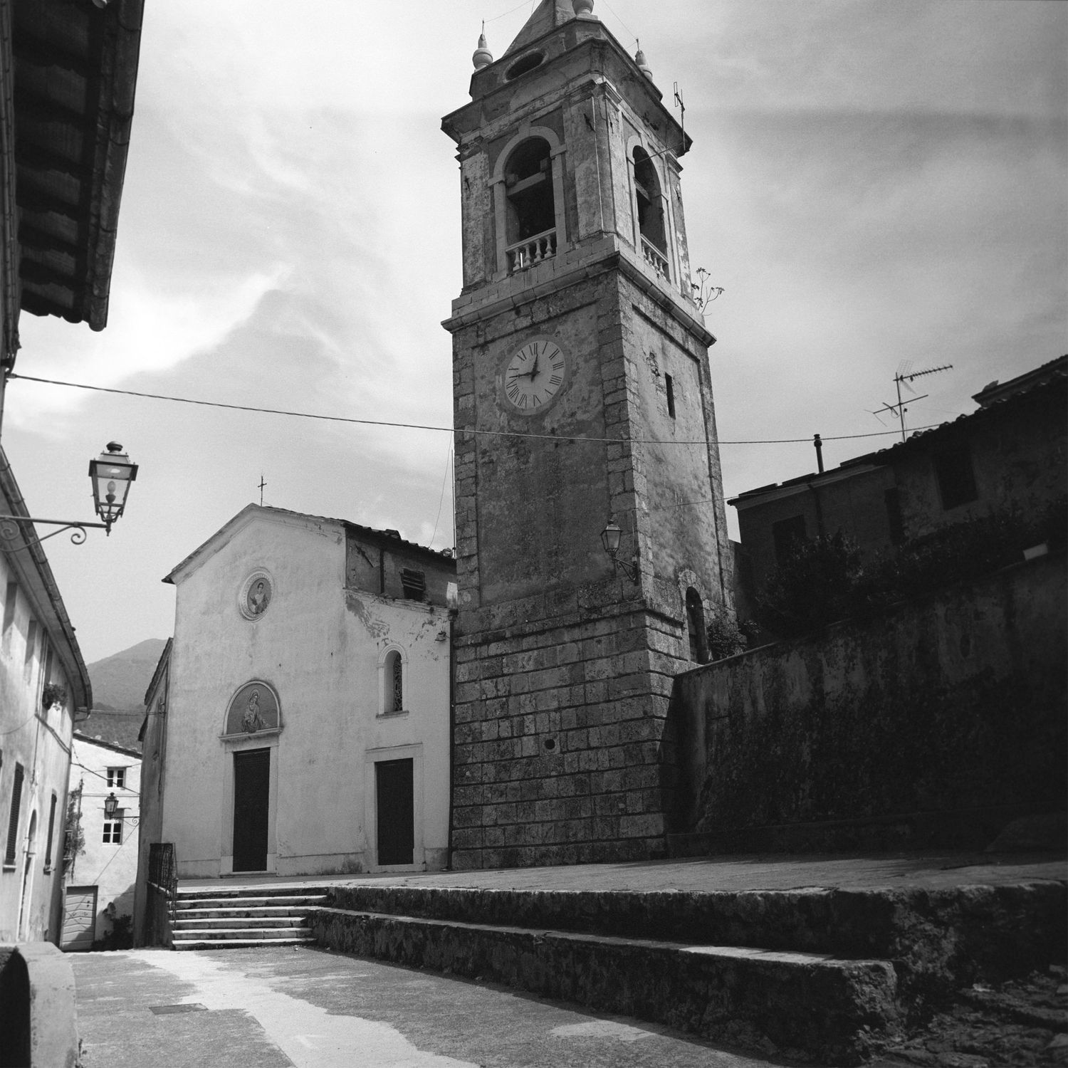 Row of historic stone churches and buildings in a European village setting.