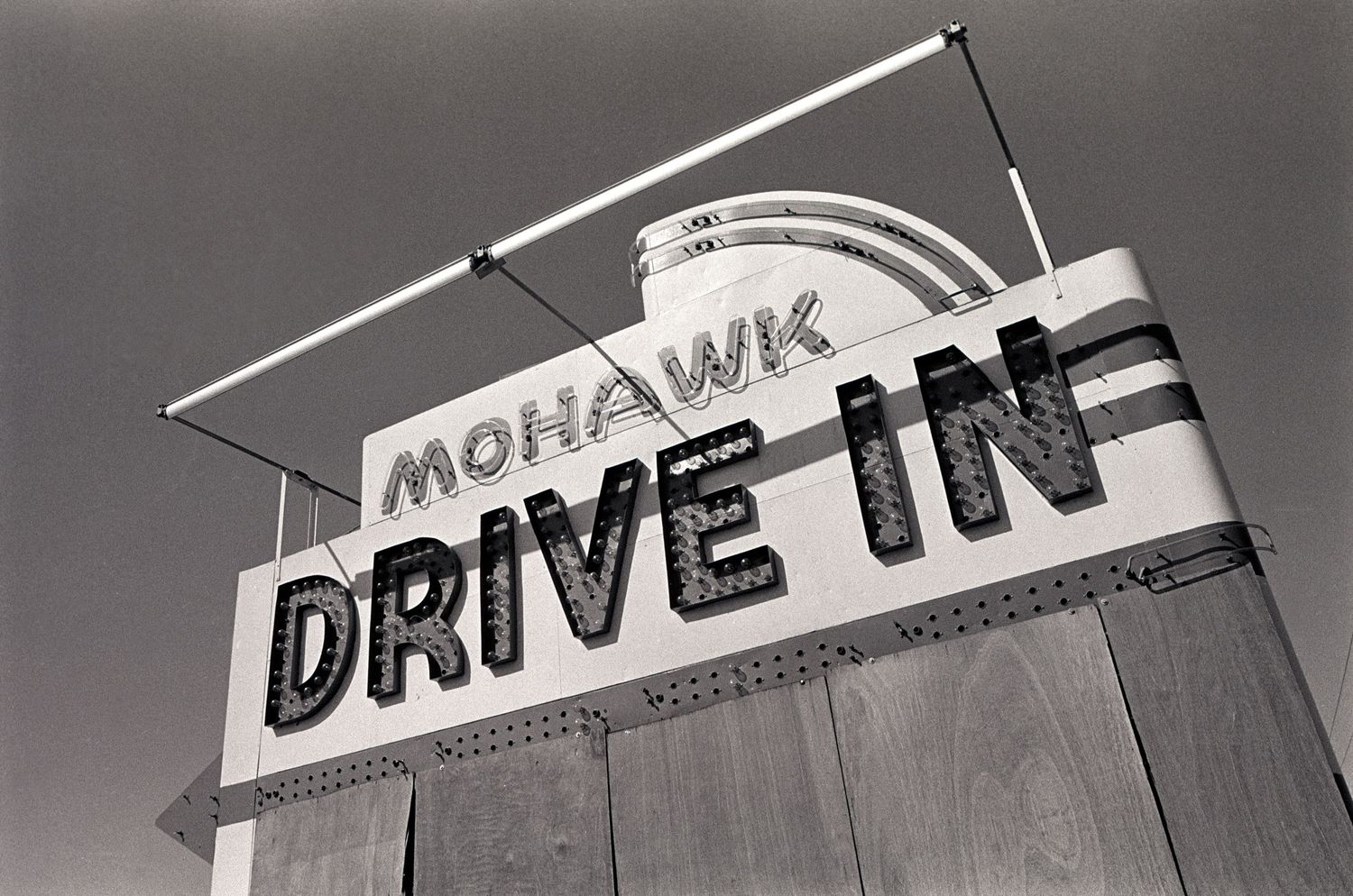 Vintage drive-in restaurant sign with retro lettering photographed from below.