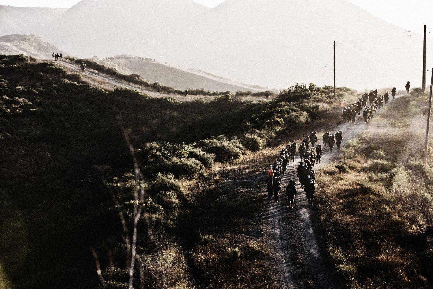 Soldiers traversing rugged desert terrain during combat training exercises.