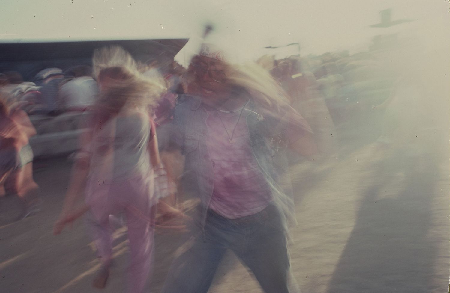 Blurred motion shot of people moving on a beach during daytime.