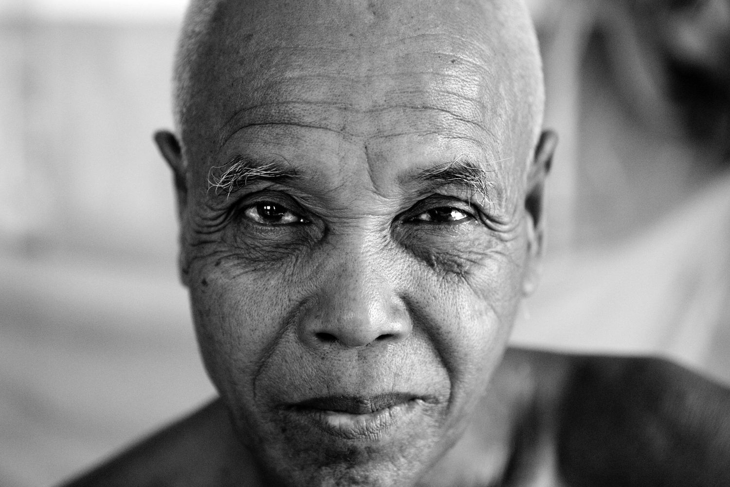Close-up portrait shot in monochrome with dramatic lighting.