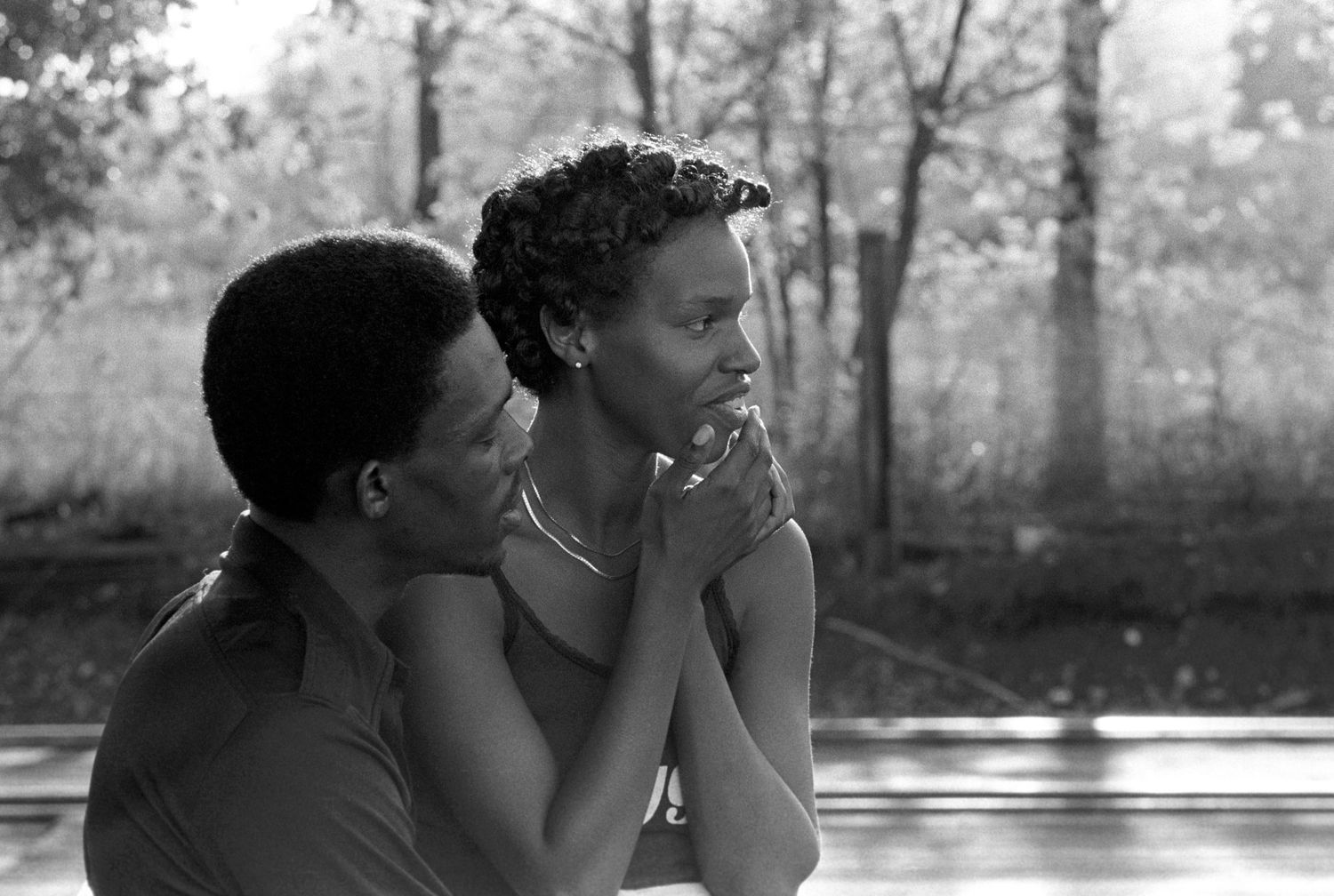 Intimate black and white portrait sequence showing a tender moment outdoors.