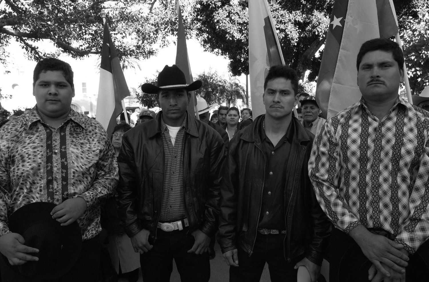 Group of uniformly dressed people standing in a line against a dark background.