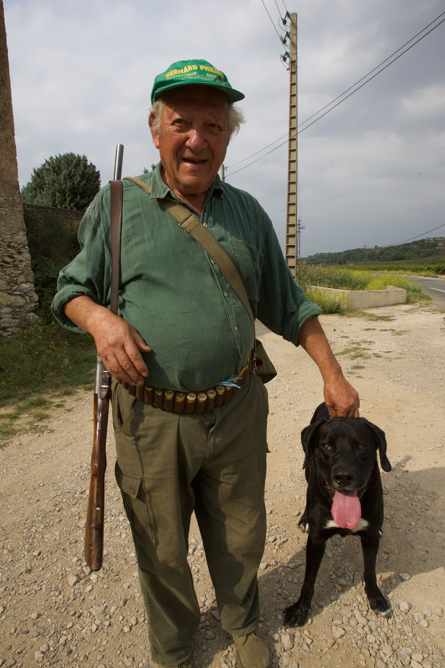 A black dog stands next to its companion on a country path.