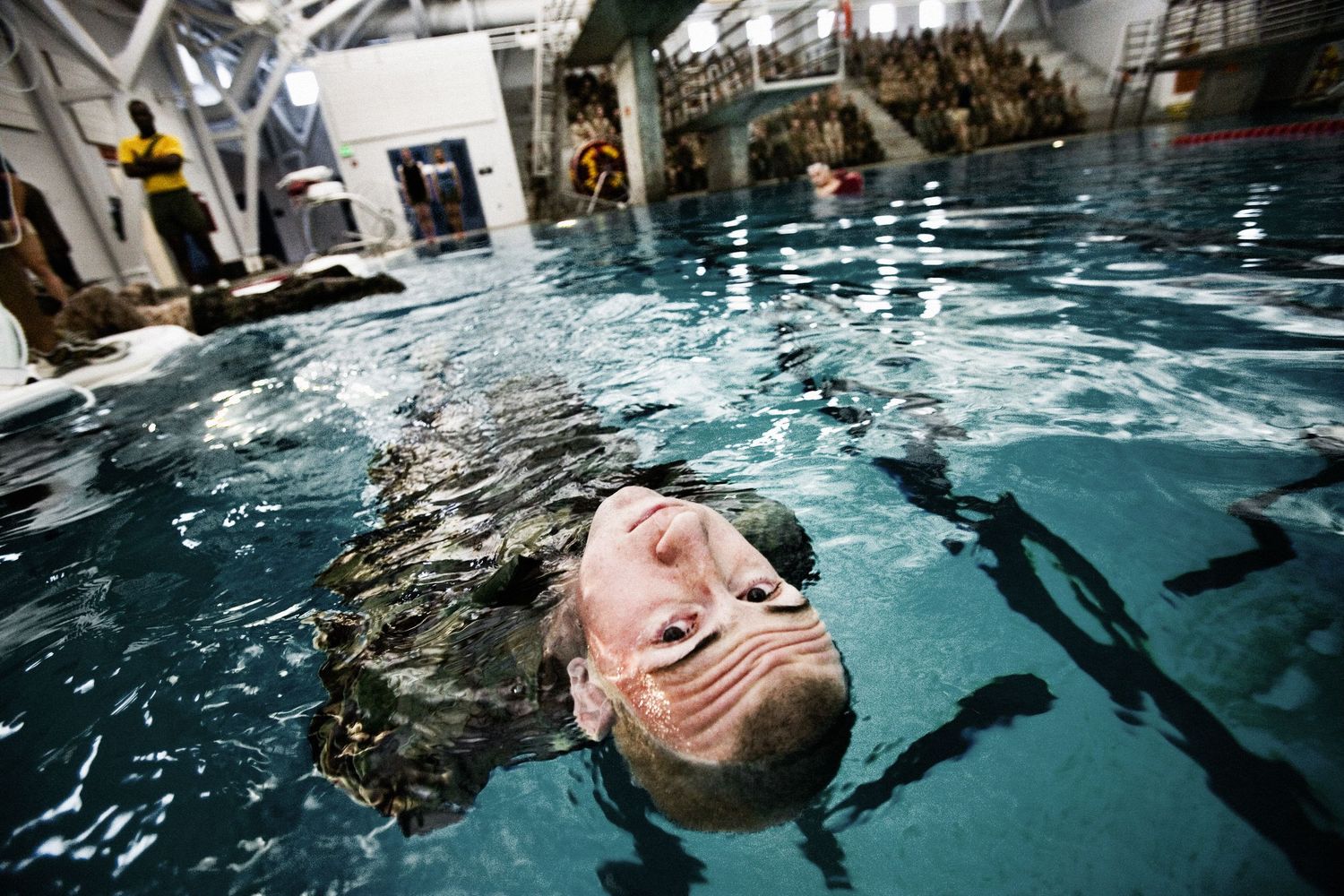 Military swimming training session showing underwater exercises in pool.