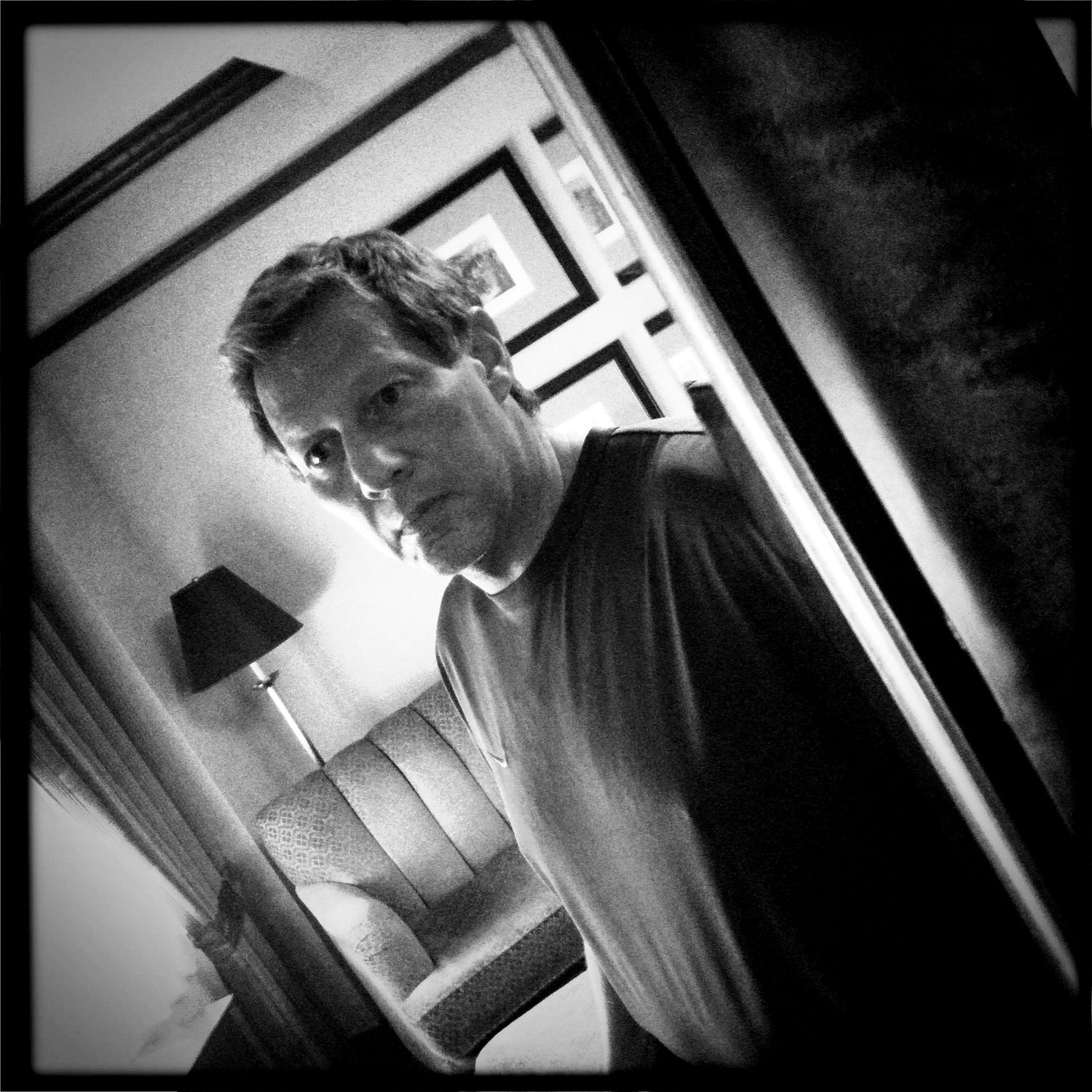Series of black and white photos showing silhouetted figure moving through dark hallway.