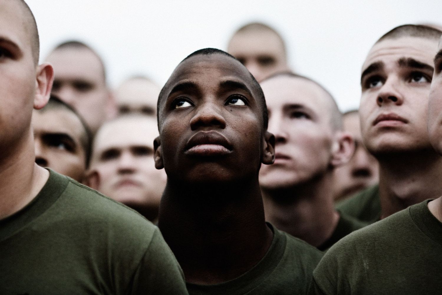 A lineup of military recruits photographed from below against a white background.