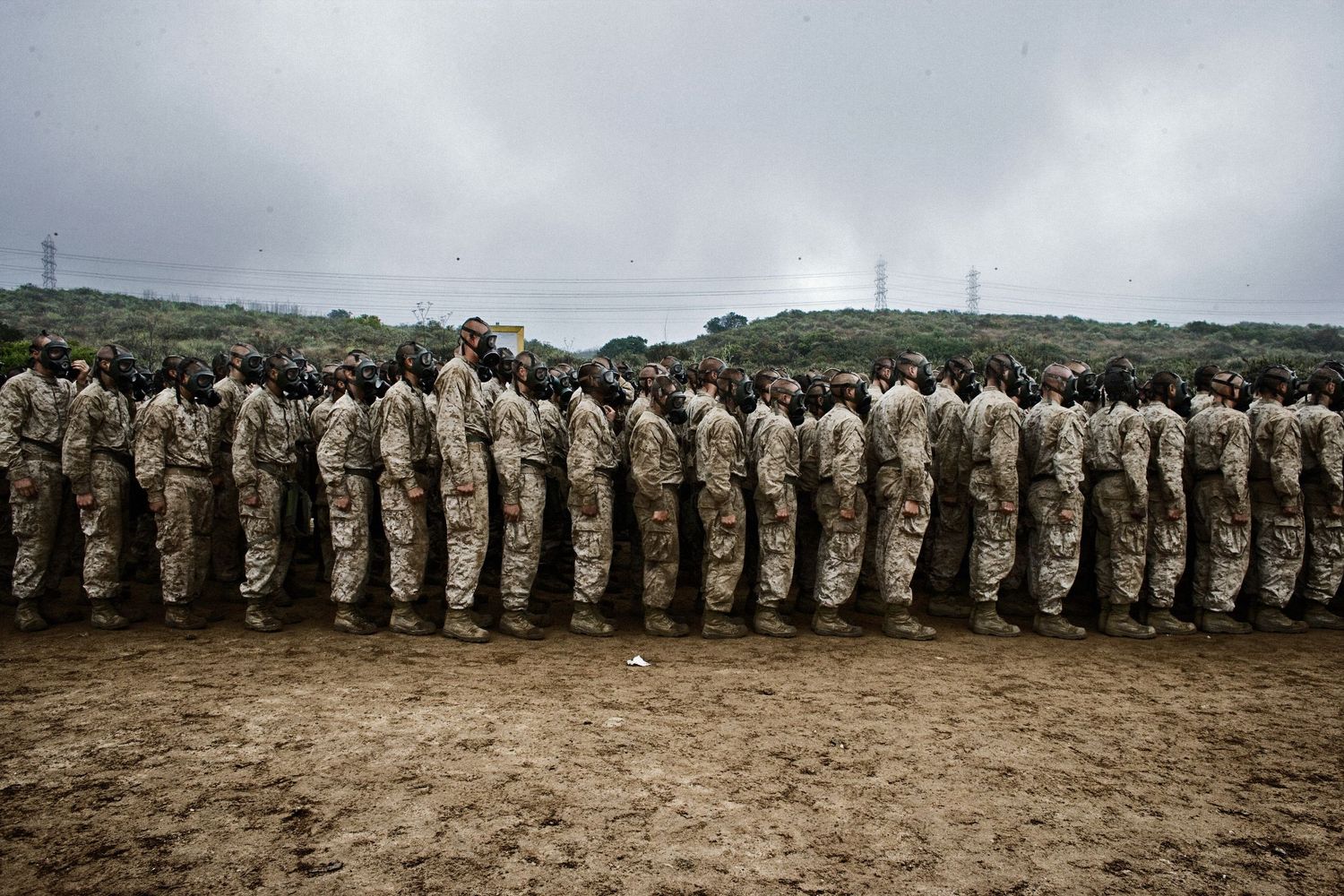 Large formation of uniformed military personnel lined up on open terrain.