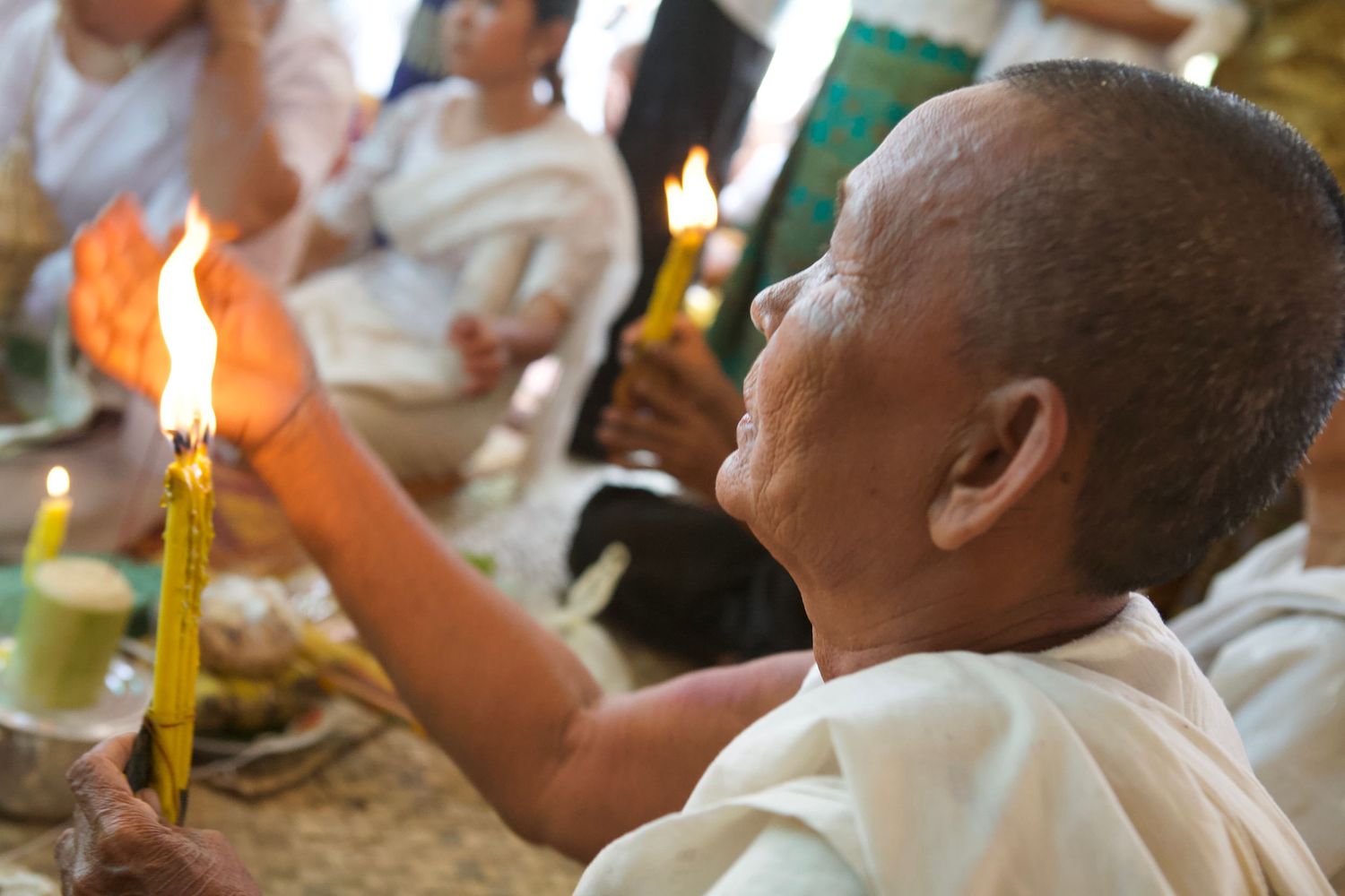 People participating in traditional ceremony or ritual with candles.