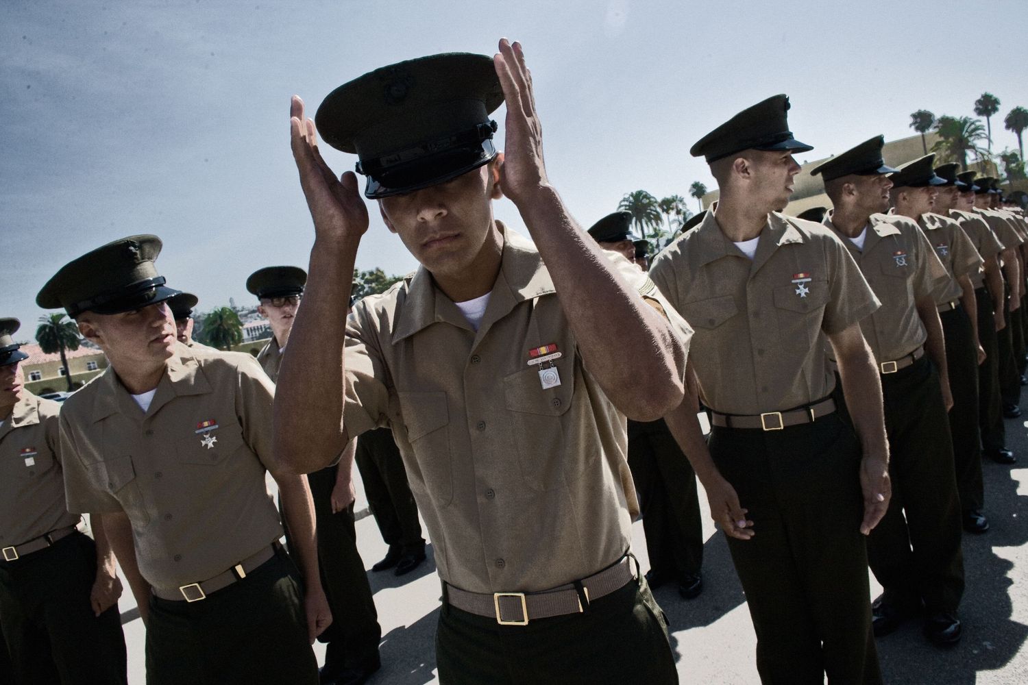 Military personnel stand in formation during an outdoor training exercise.