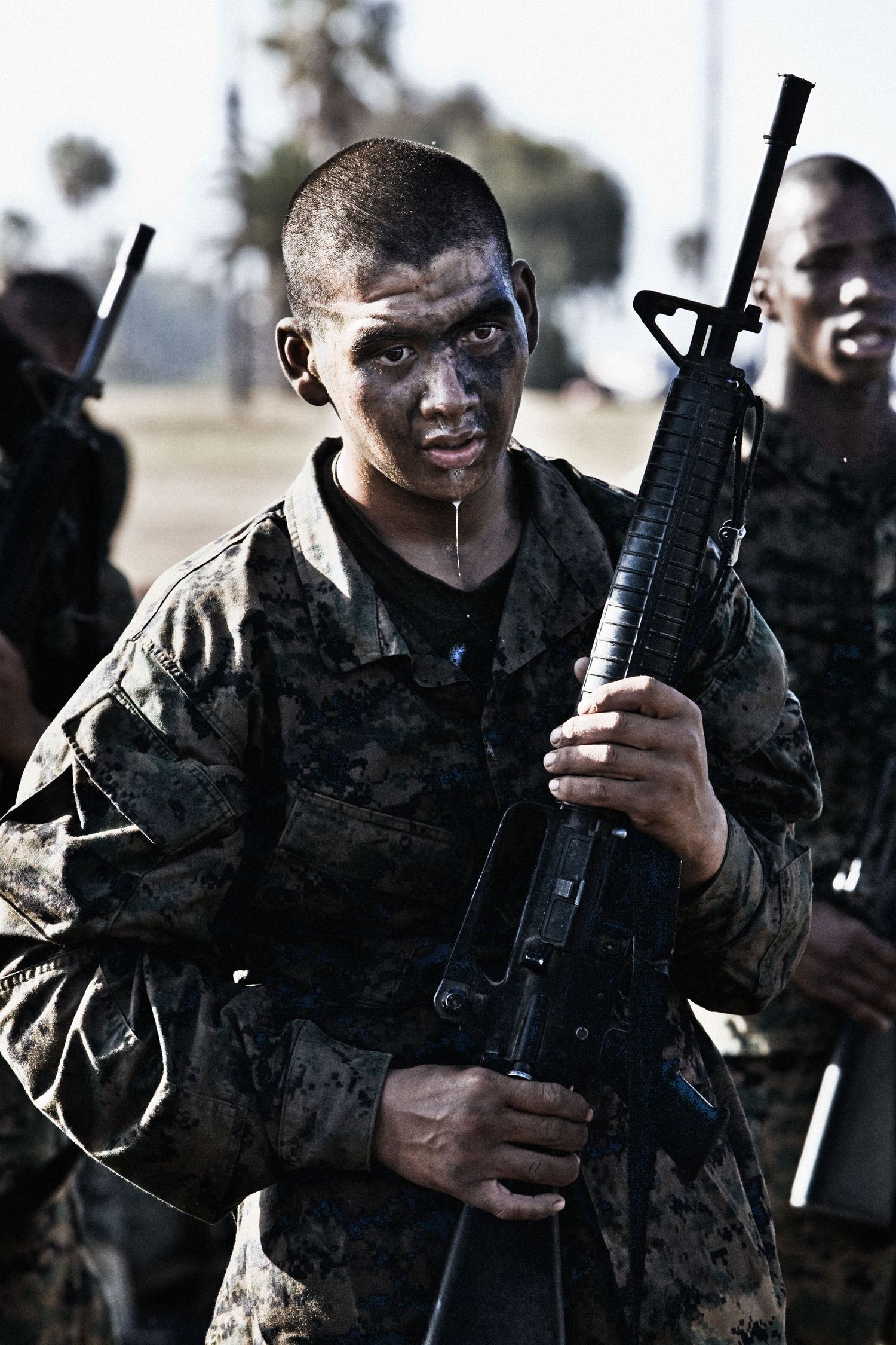 Soldiers in camouflage uniforms holding rifles during military drills.