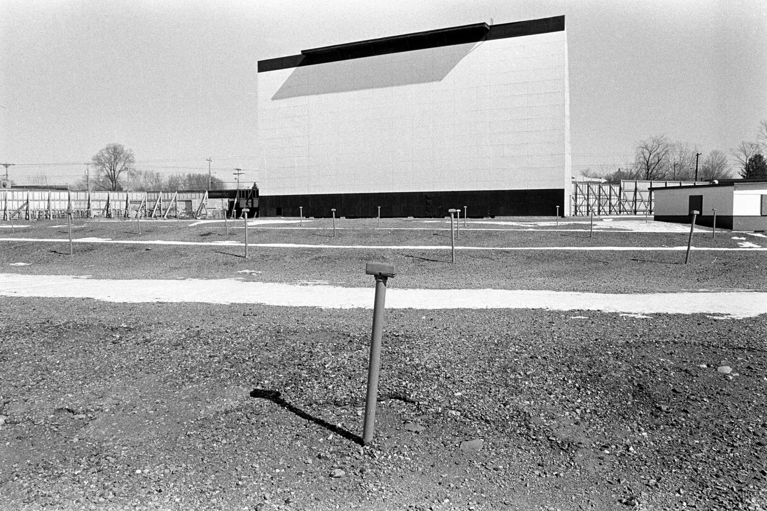 Long flat rural landscape with scattered buildings visible on the horizon in black and white.
