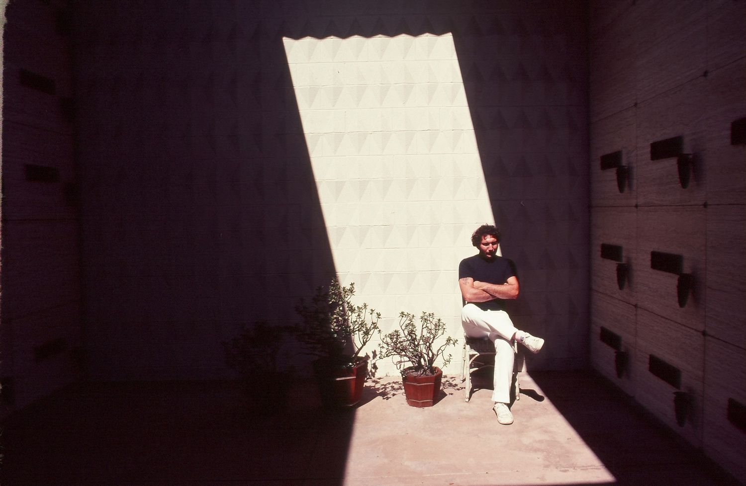 Minimalist architectural scene with white walls casting strong shadows.