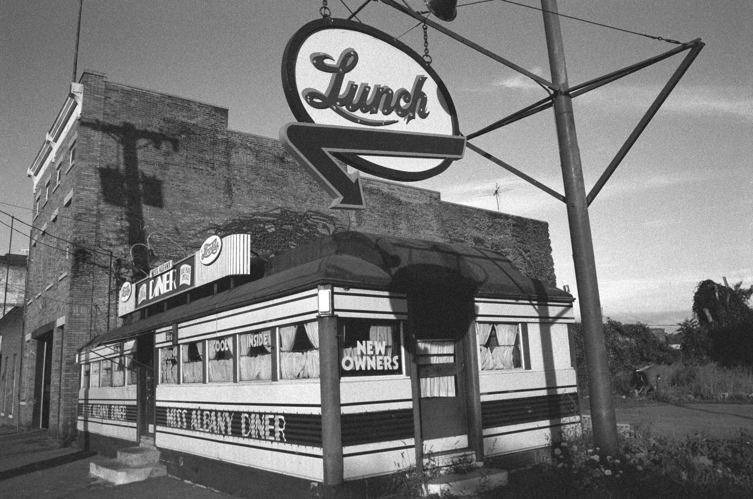 Vintage retail store signs and storefronts captured in black and white photography.