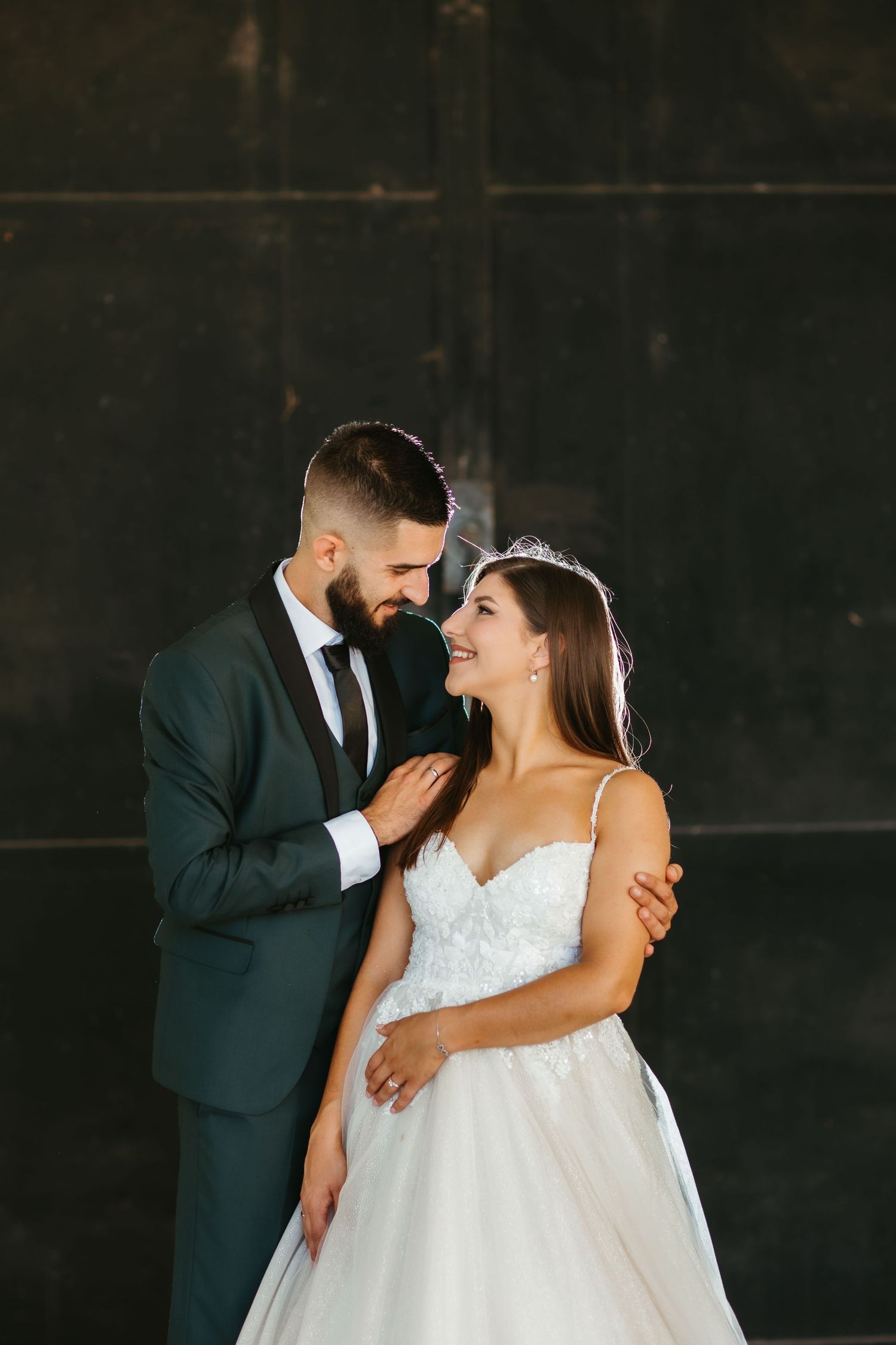 A bride and groom share a romantic kiss pose during their wedding photoshoot.