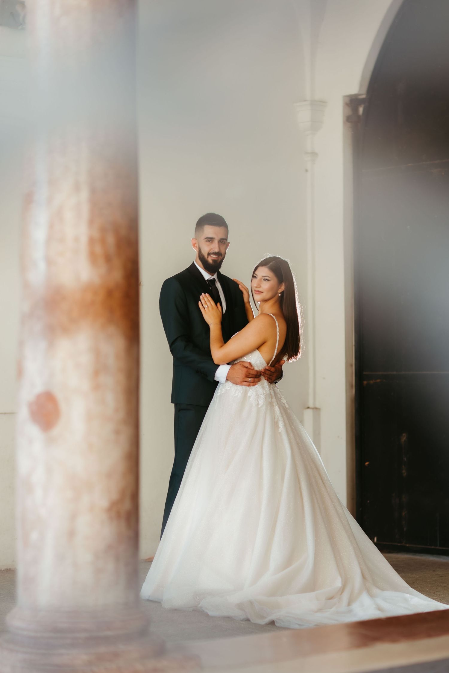 Romantic wedding photos showing couple in elegant attire with bride in flowing white ball gown and groom in black suit.