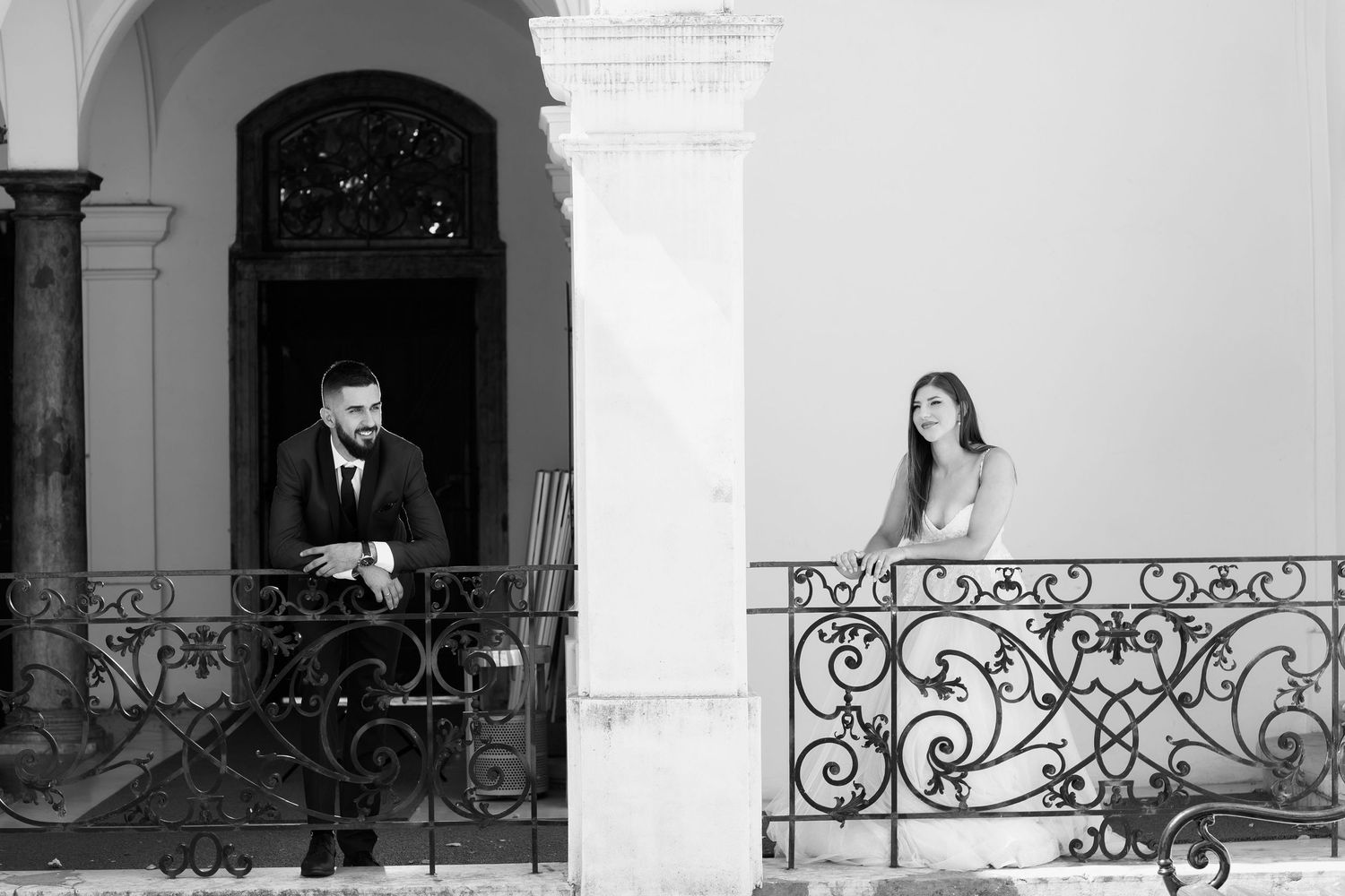 A series of black and white photography portraits showing figures on classic iron balconies and doorways.