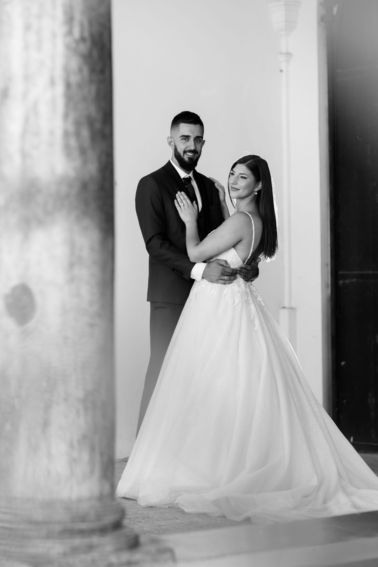 A series of romantic black and white wedding photos showing a couple dancing and embracing between elegant columns.
