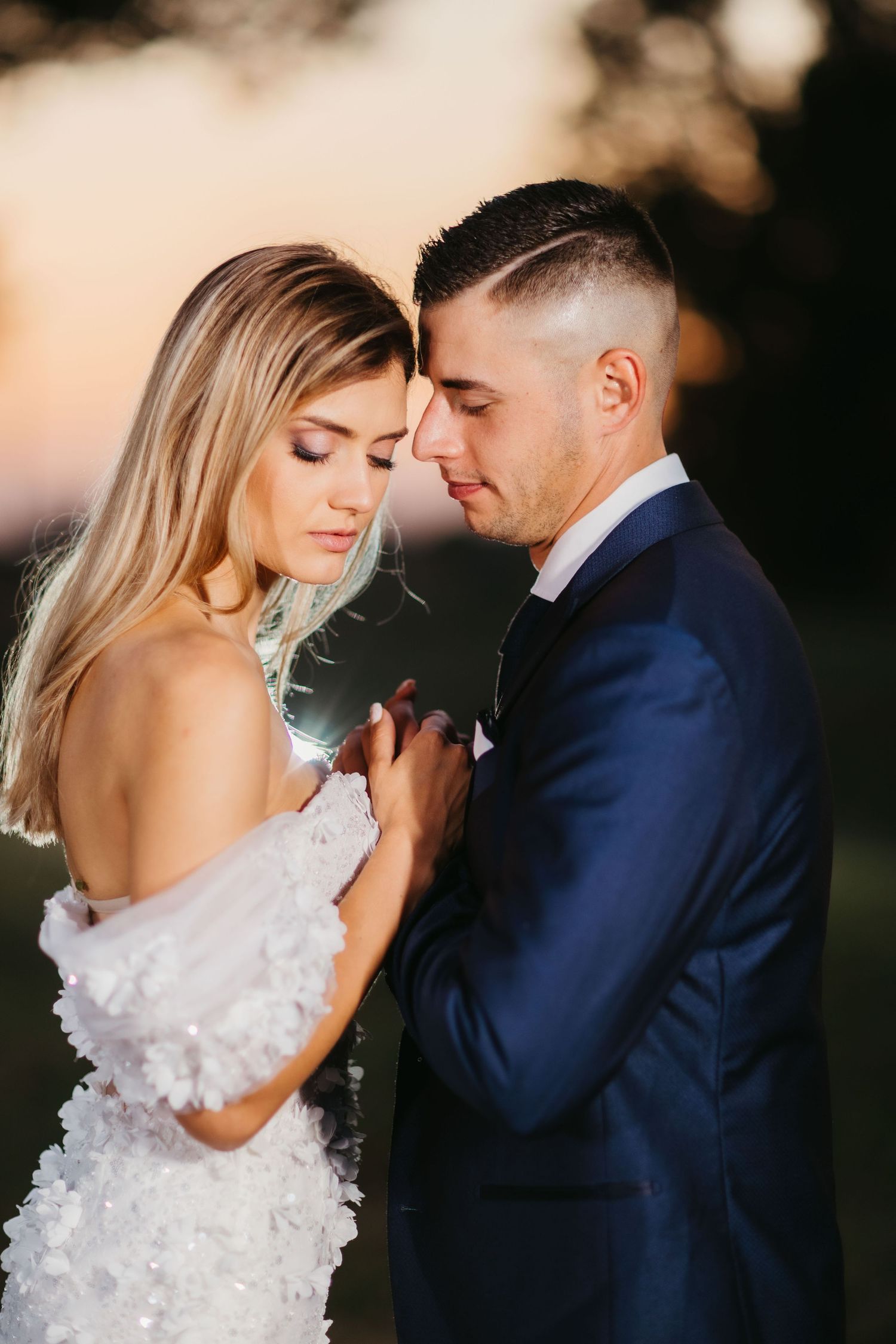 Intimate sunset portrait of wedding couple in formal attire.