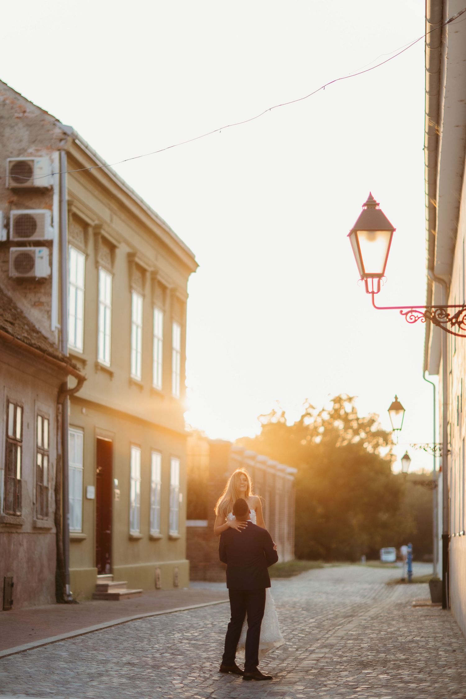 Sunset street scene with vintage lamp posts and historic buildings creating romantic ambiance.