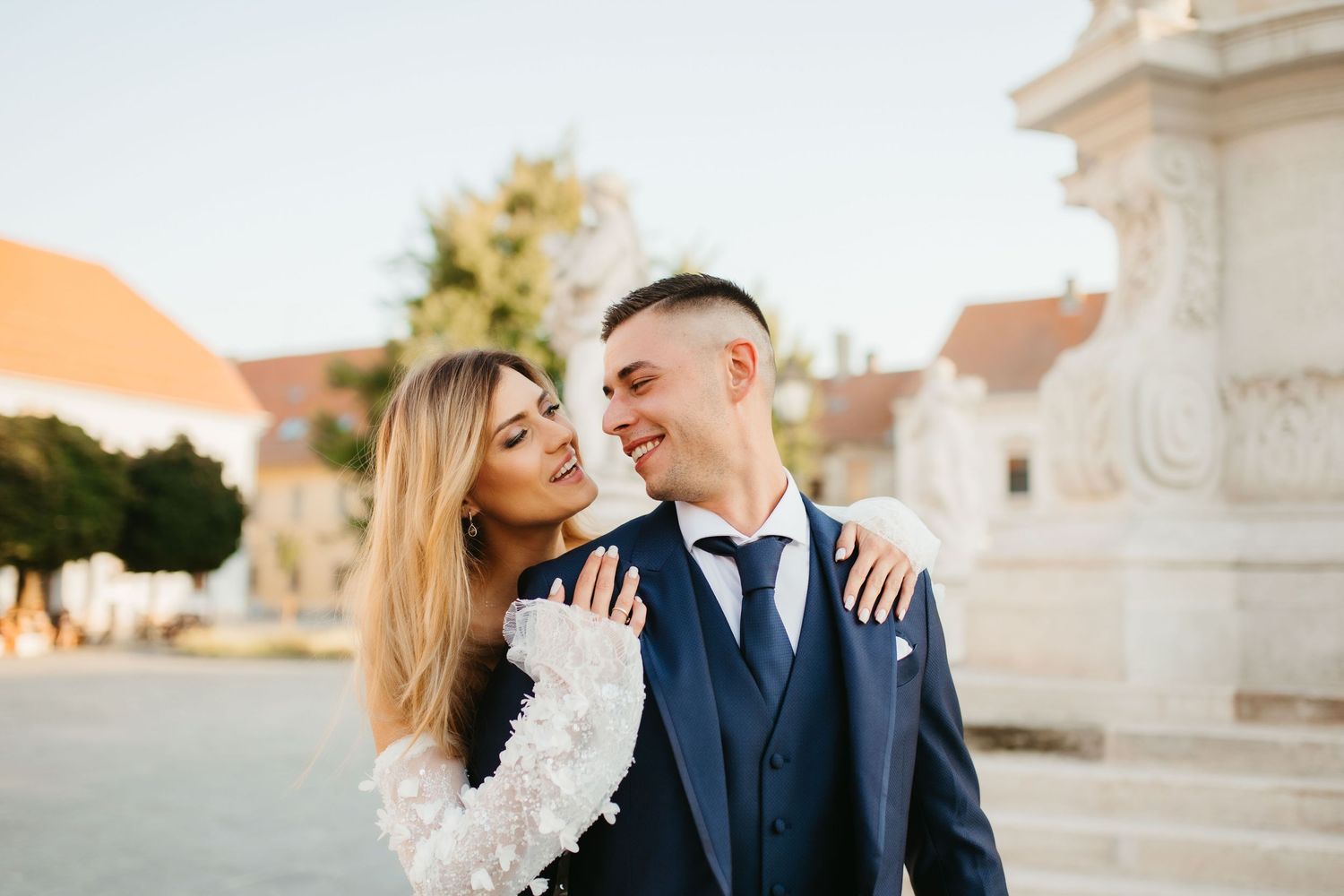 Romantic wedding couple shares joyful moment against sunset backdrop.