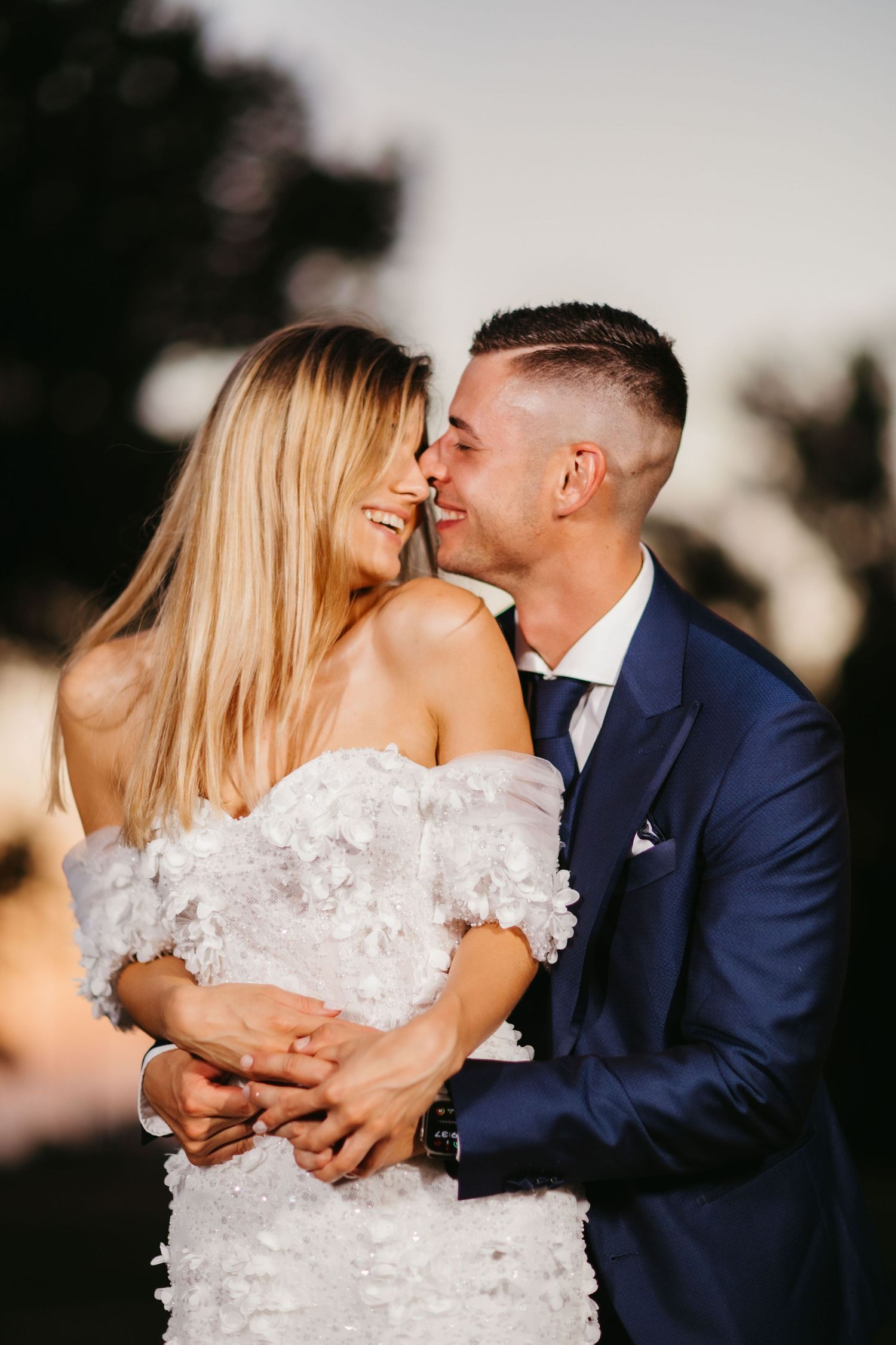 Candid wedding portrait captures joyful intimate moment between newlyweds during sunset photo session.