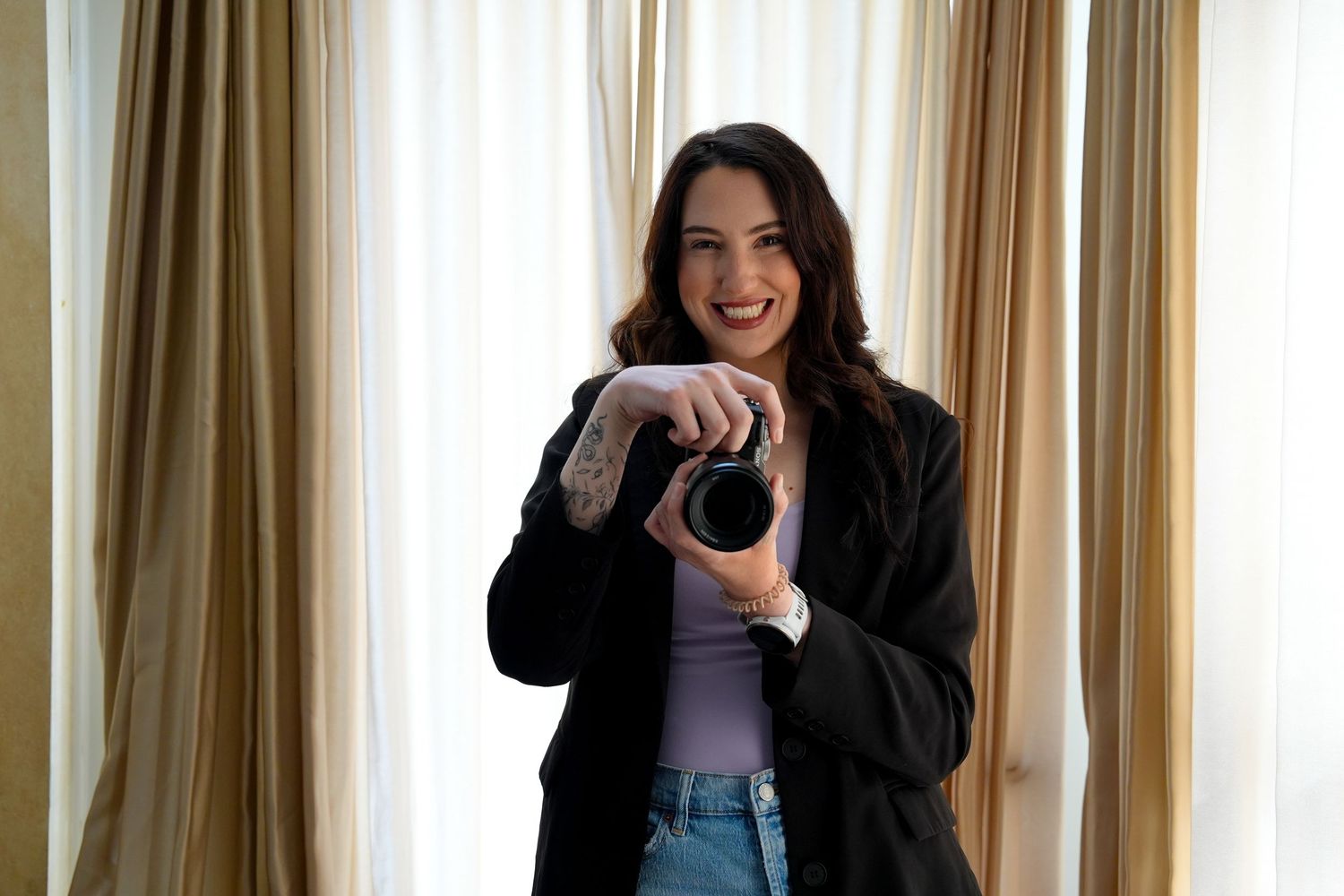 A sequence of four photos showing someone modeling jeans and a dark jacket while posing against a curtained wall.