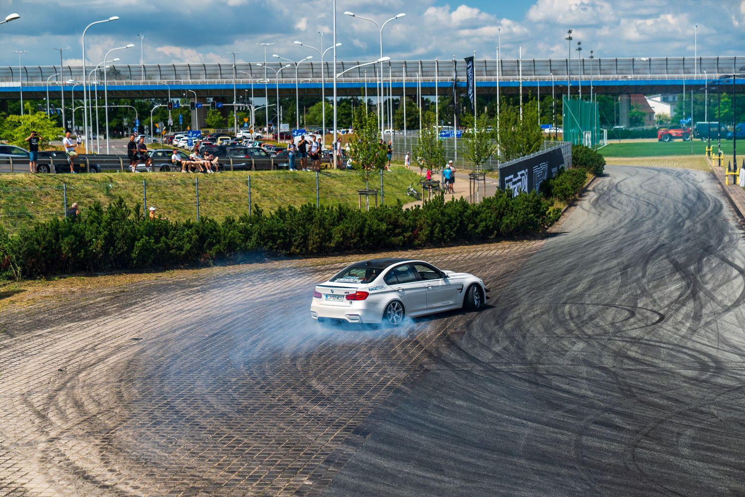 Tire marks on asphalt with scenic landscape and cloudy sky in the background.