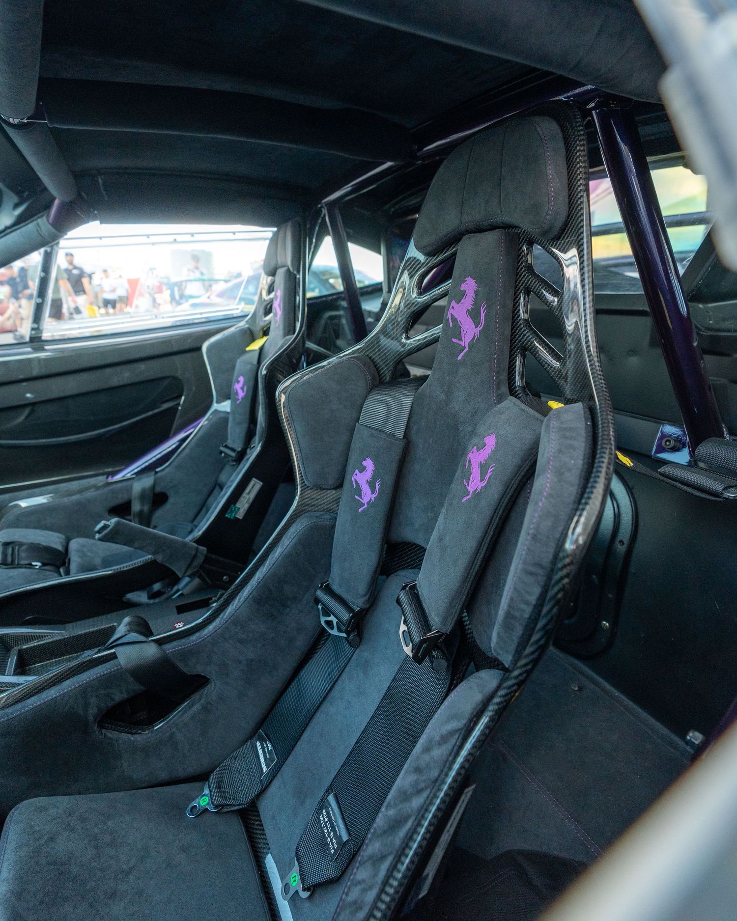 Custom racing bucket seats with purple accents in modified sports car interior.