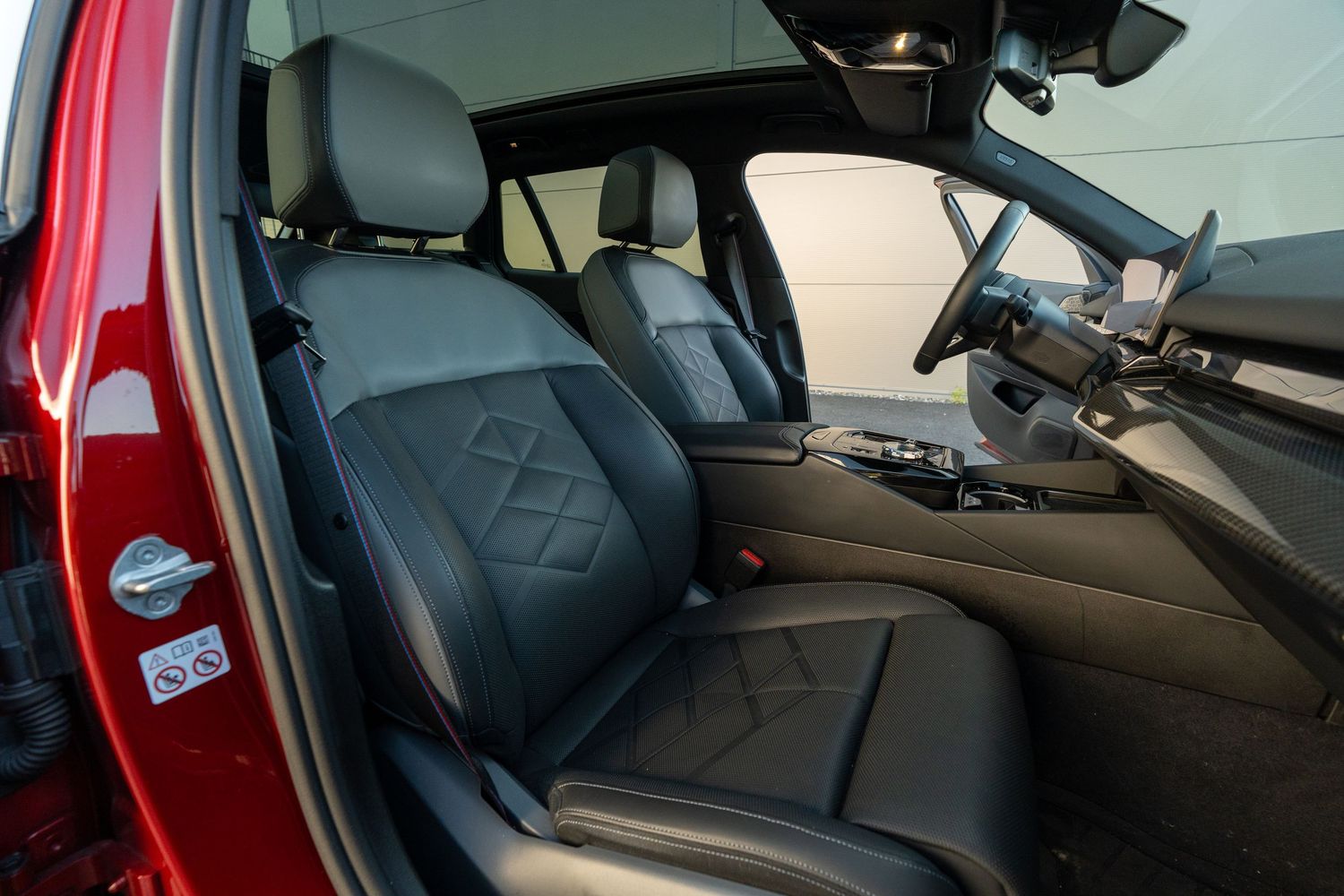 Side view of BMW interior showing front and rear leather seats with diamond pattern.