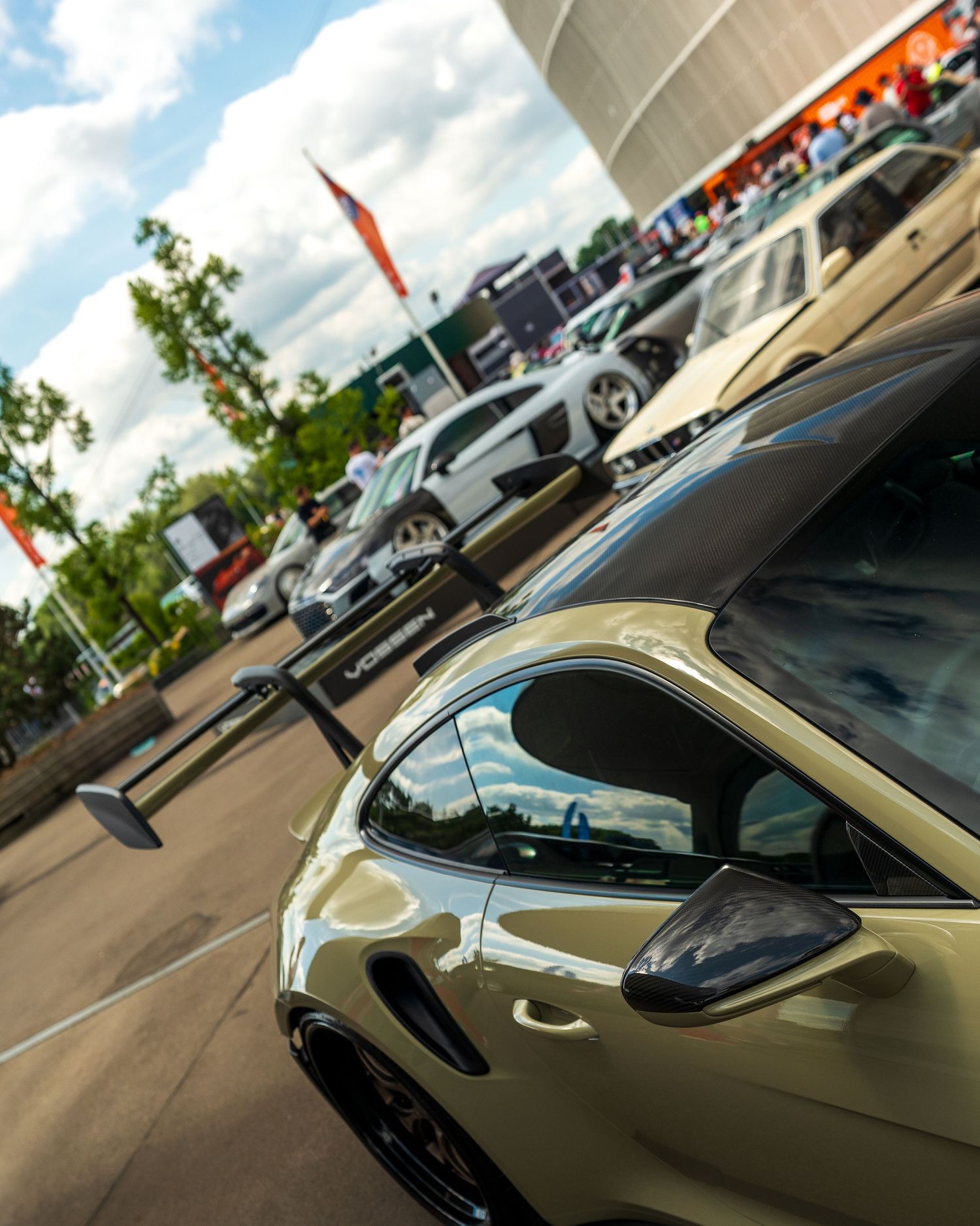 Sleek black sports car silhouettes lined up in a diagonal view at a car show.