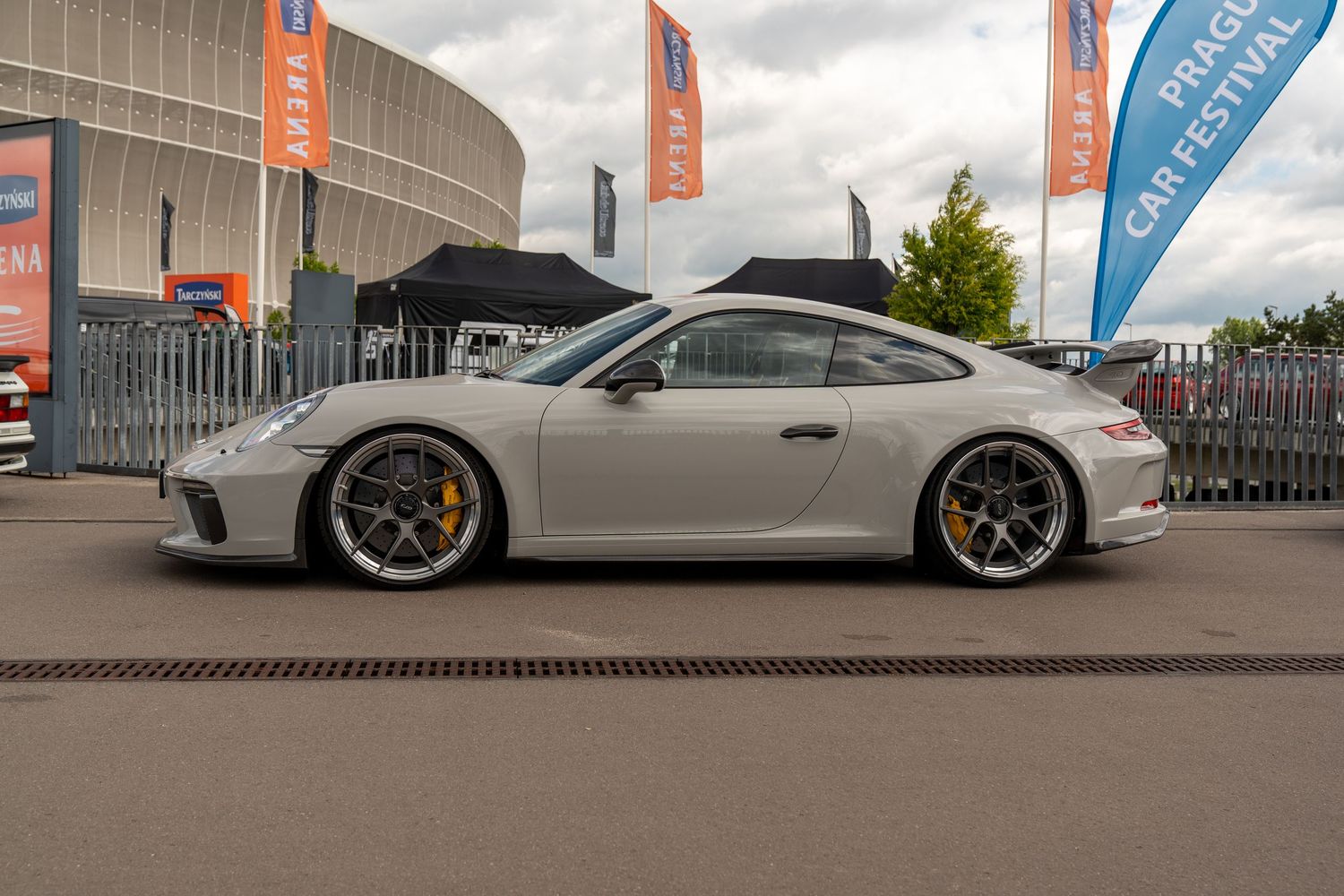 White Porsche sports cars lined up at outdoor automotive exhibition.