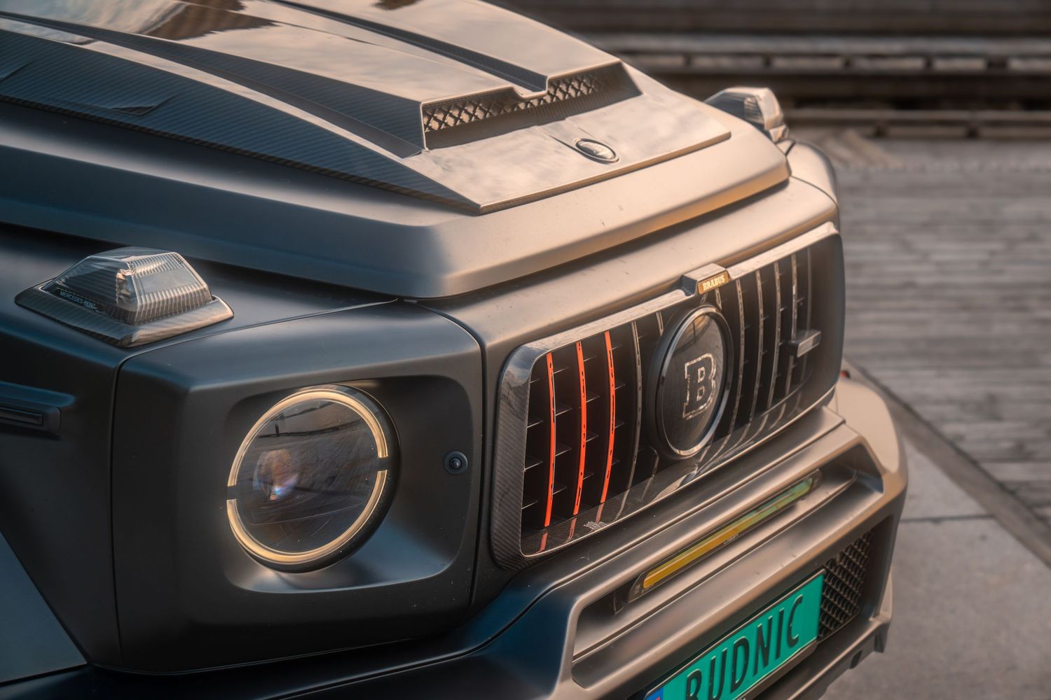 Front grille and headlight detail of a modified black Mercedes G-Wagon showing Brabus styling elements.