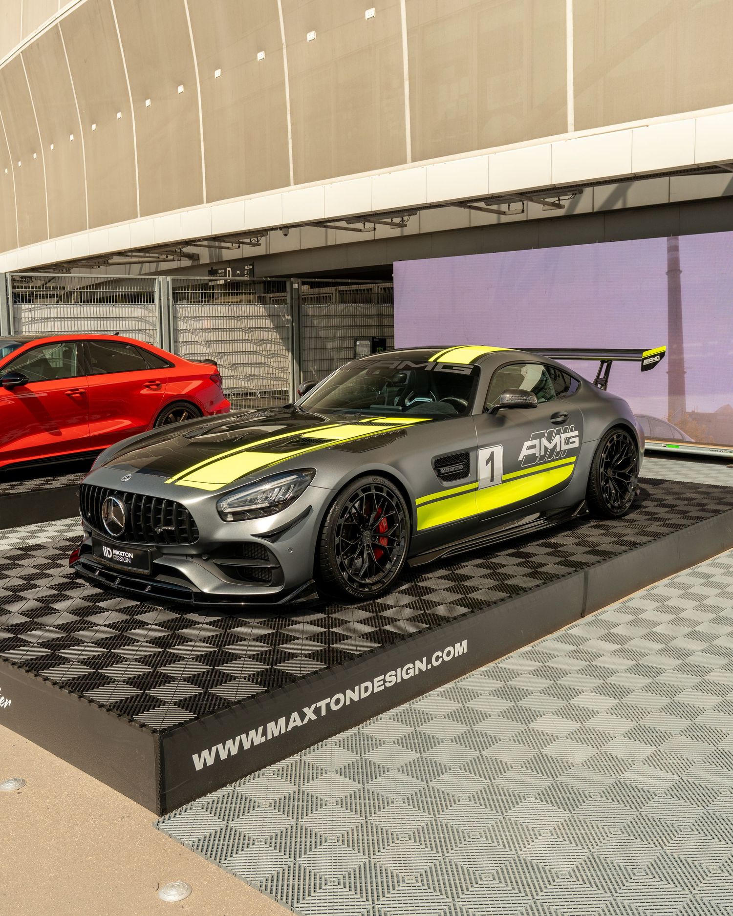 Custom Mercedes-AMG sports car with neon yellow accents displayed on checkered floor.
