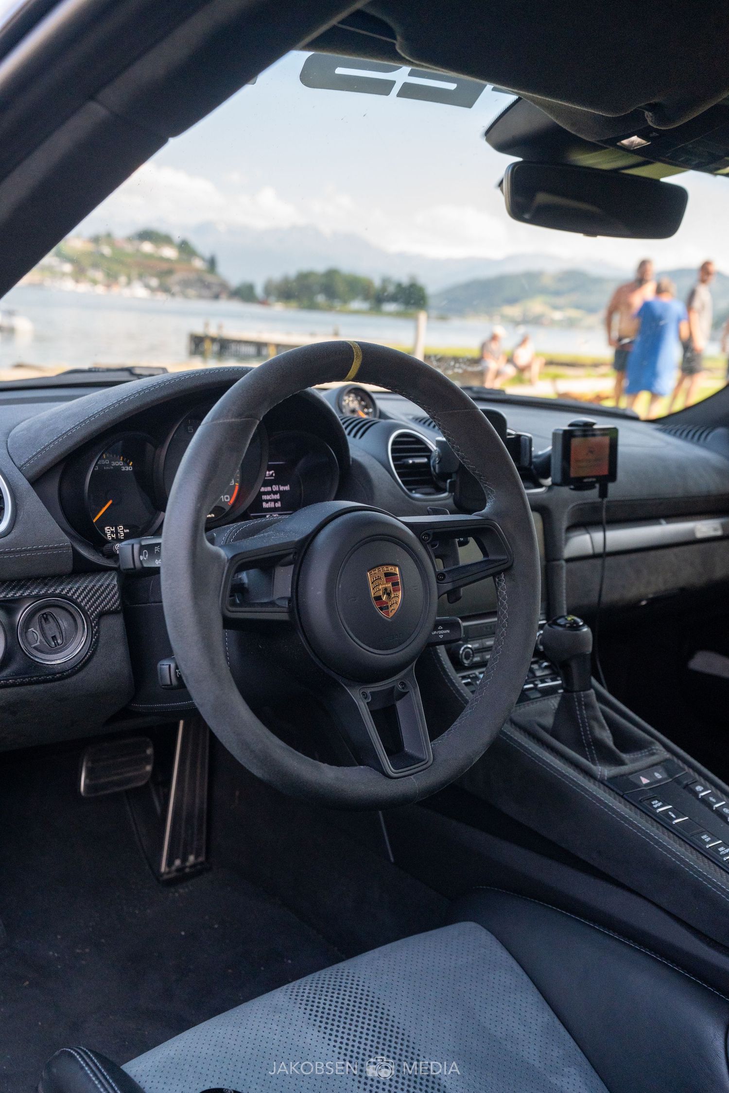 Interior view of a Porsche sports car showing the steering wheel and dashboard controls.