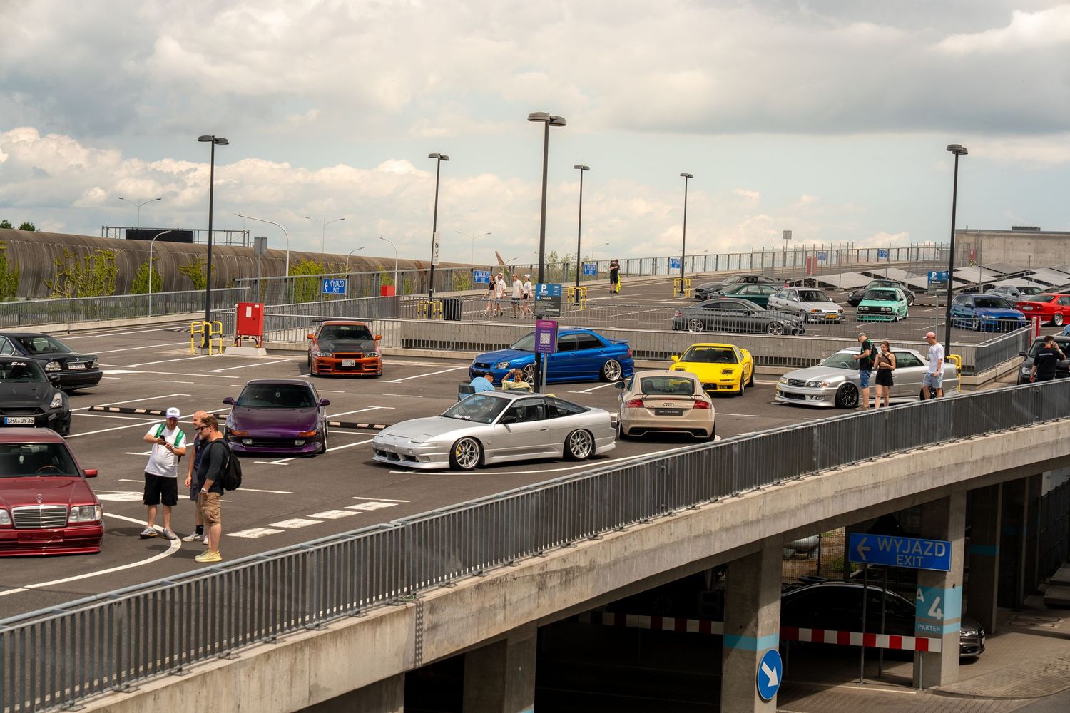 Elevated view of a car show parking area with various colored vehicles.