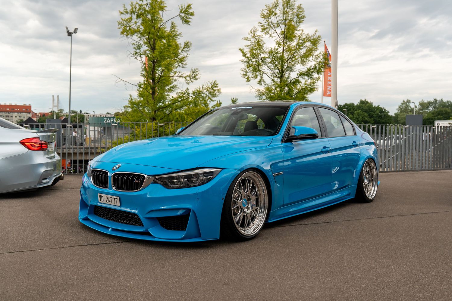 Modified BMW M3 in Miami Blue featuring aggressive stance and custom wheels.